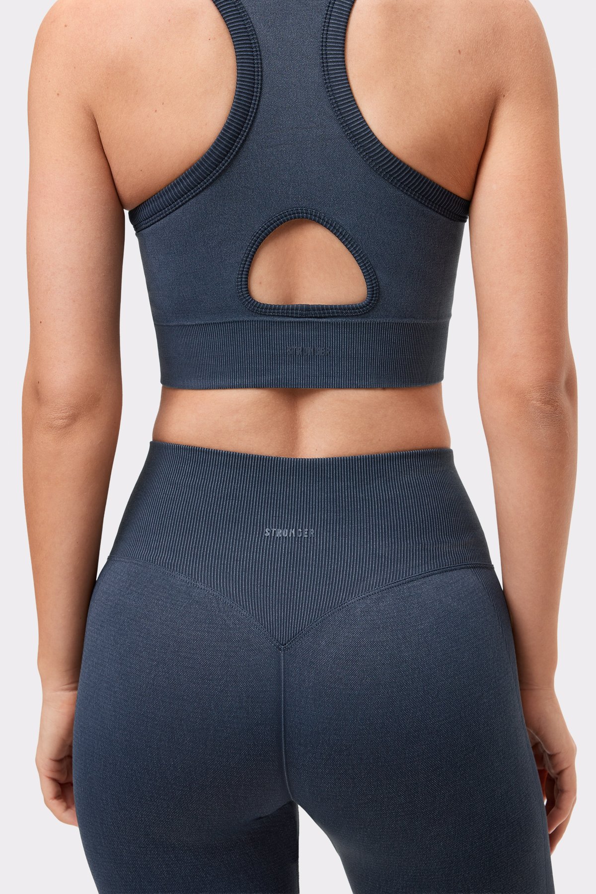 Nahaufnahme der Rückseite des Washed seamless high neck bra in Schwarz mit Keyhole-Ausschnitt und gerippter Textur.