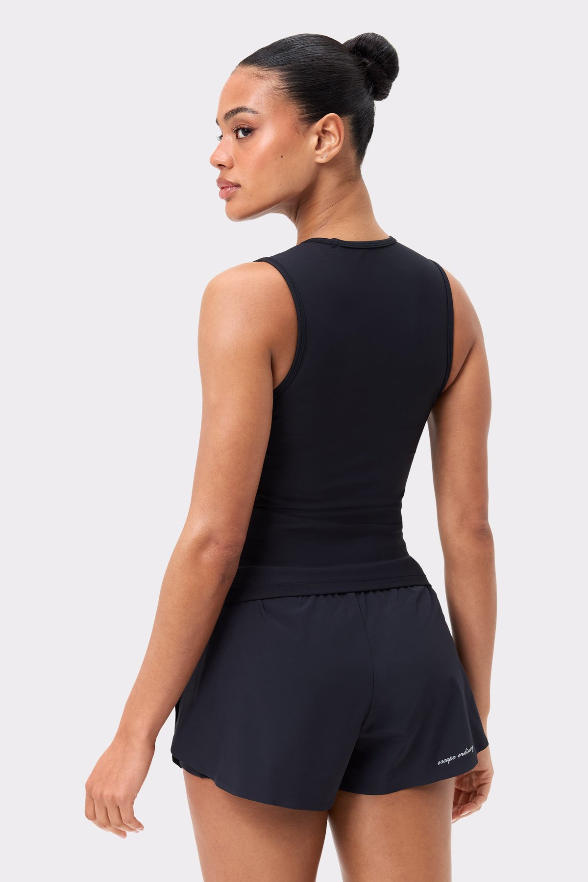Back view of the black Signature Slim Tank Top by Stronger, featuring a slim fit and recycled performance fabric.