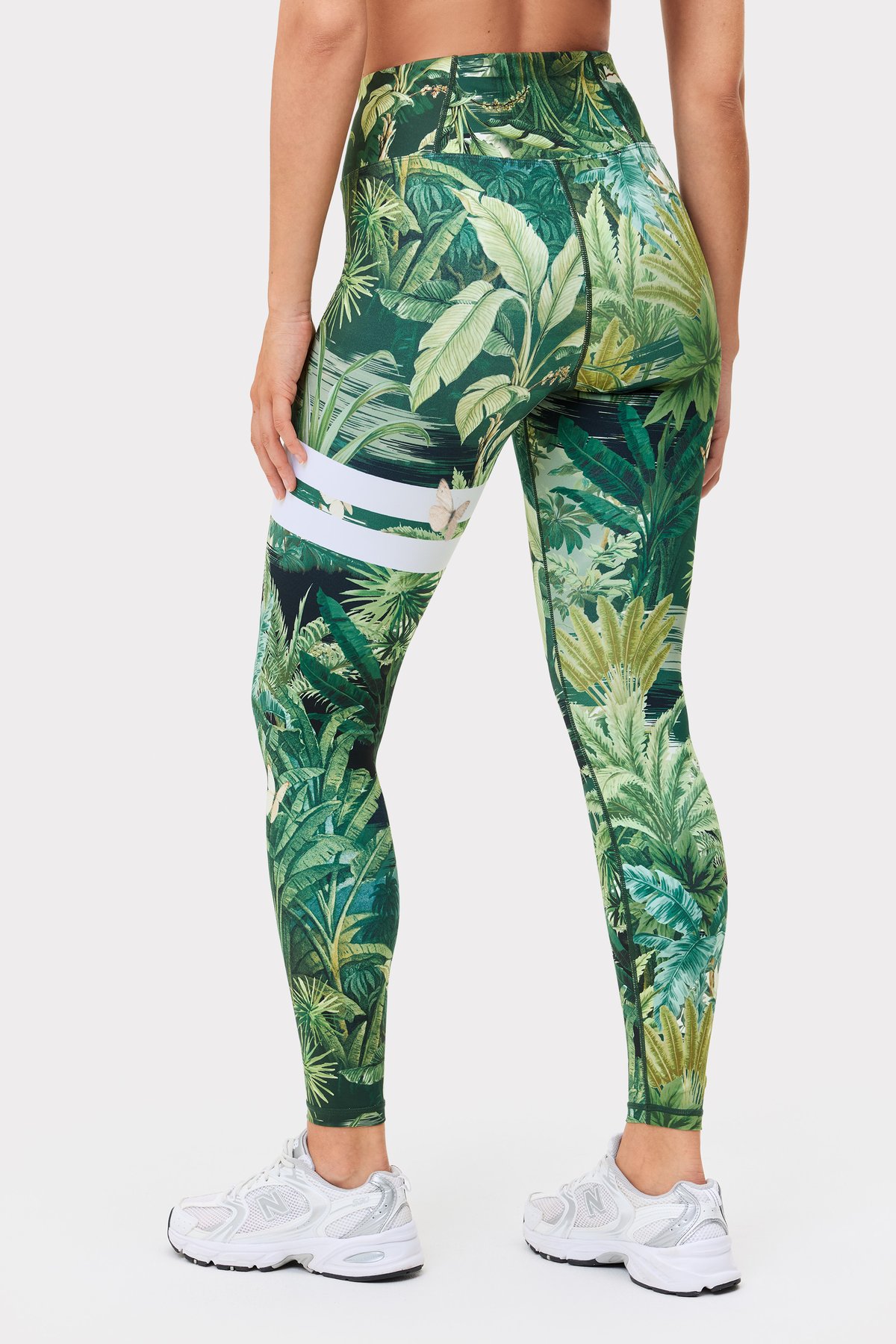 Ganzansicht der Rückseite eines Models in den Explore Printed Leggings mit tropischem Blättermuster von Stronger.