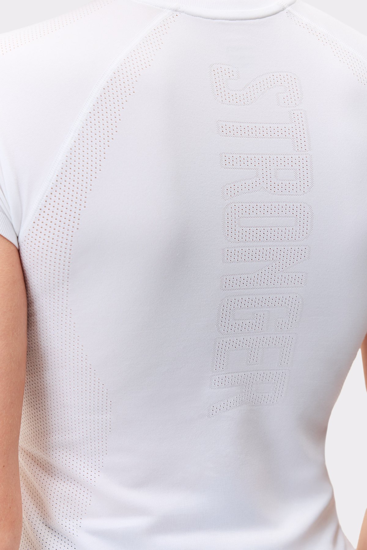 Close-up of the white Seamless Performance T-shirt, featuring a breathable perforated Stronger logo on the back.