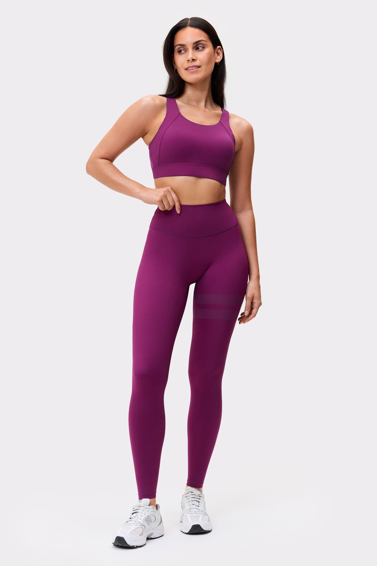 Model wearing the aubergine purple Bounce Sports Bra from stronger with matching high-support activewear leggings.