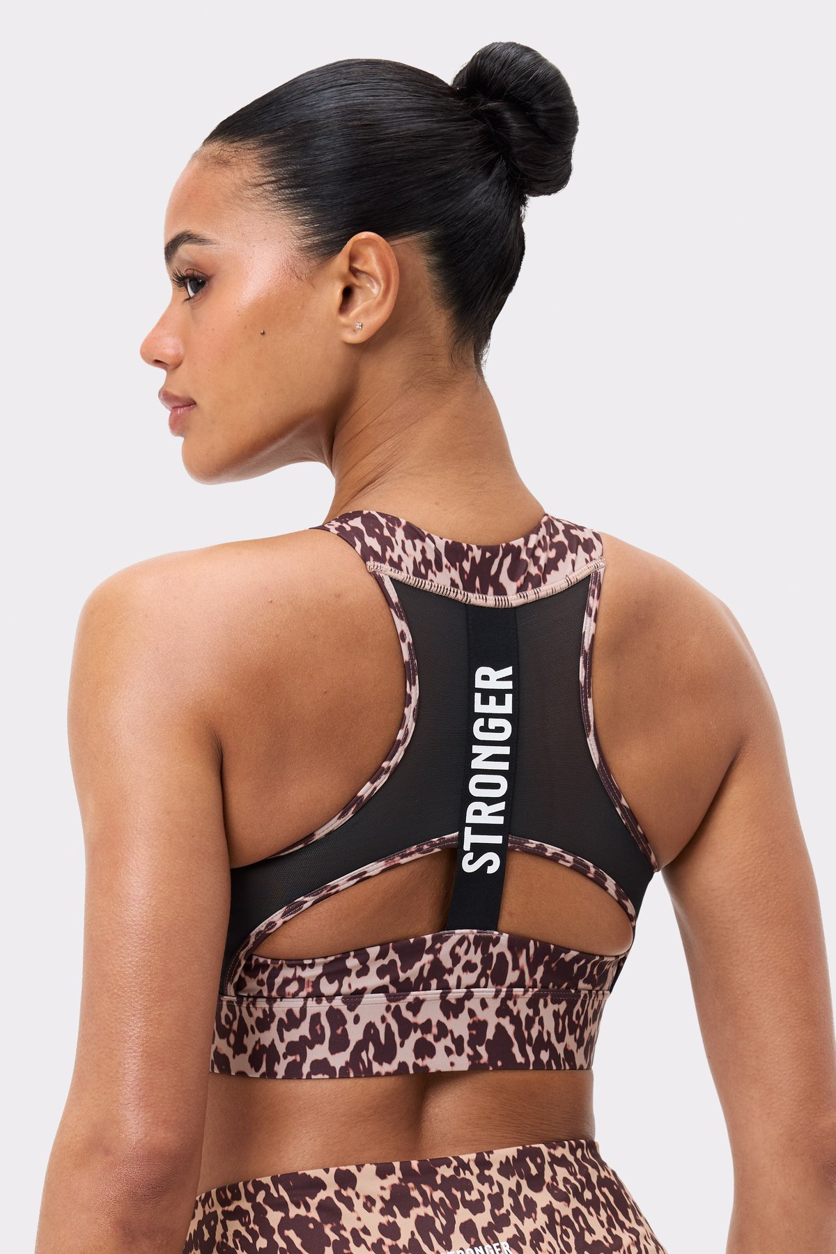 Back view of Stronger's Bounce Sports Bra in Leo Rush print, featuring a black mesh panel and vertical logo.