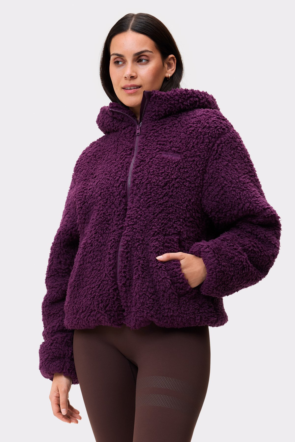 Model wearing the dark purple Hooded Pile Jacket from Stronger, showcasing its soft texture and comfortable full-zip design.