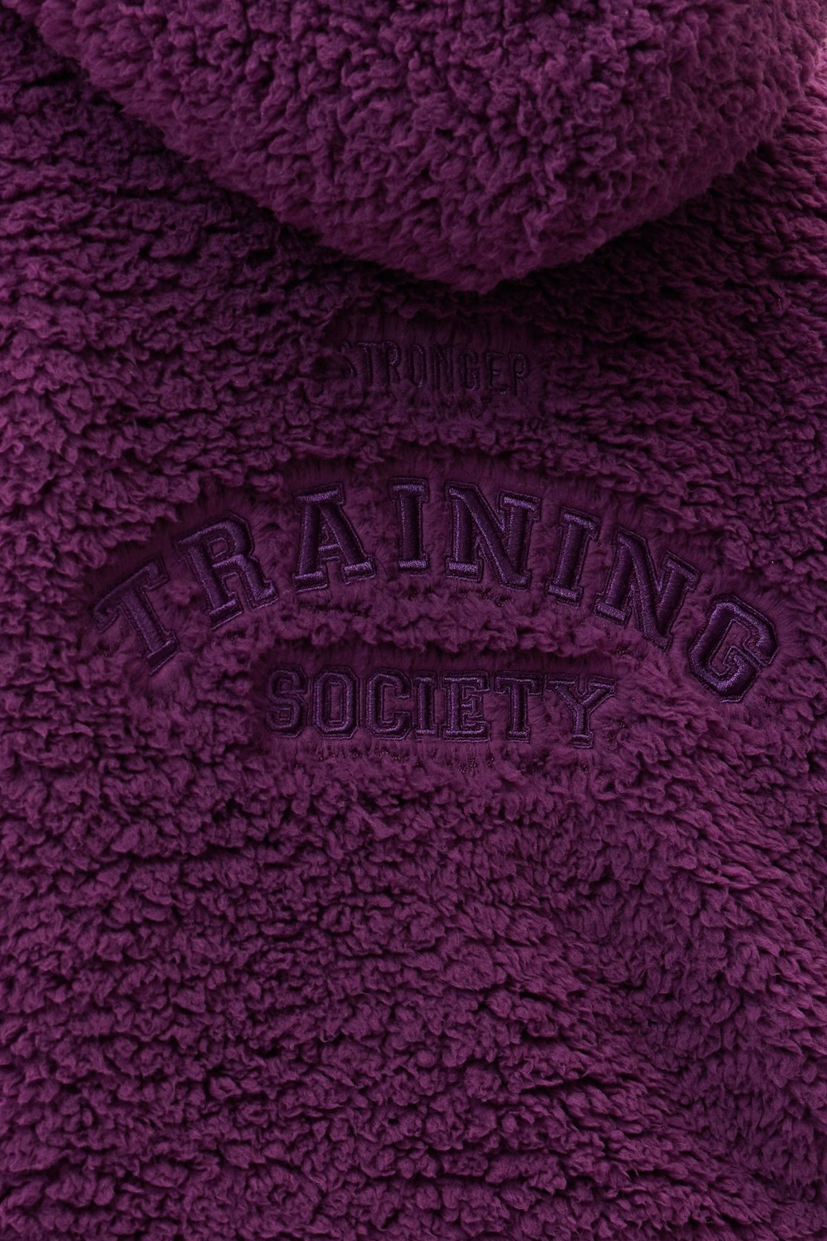 Close-up of the dark purple Hooded Pile Jacket by stronger, showing the embroidered back graphic details.