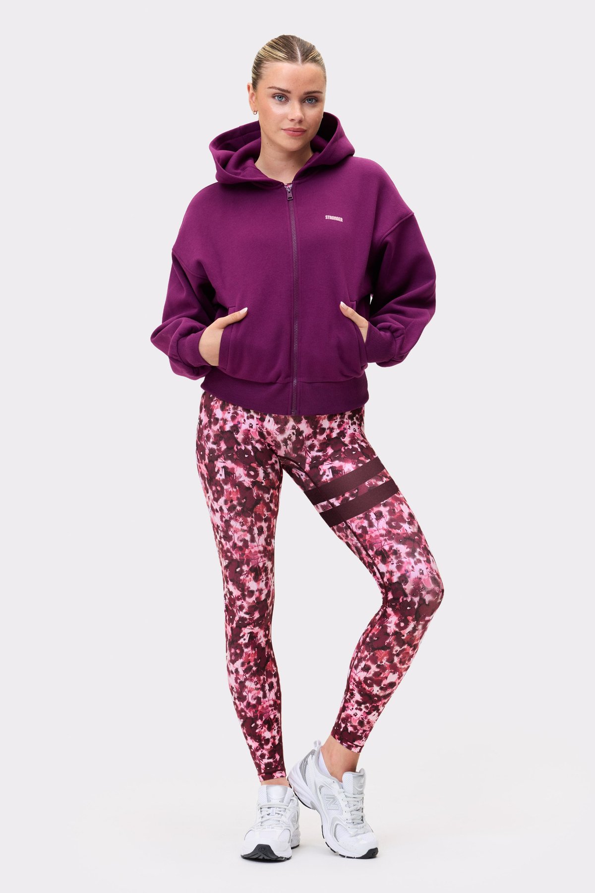 Model wearing the aubergine purple Relaxed Full Zip Hoodie from stronger, showing the full front zip and relaxed fit.