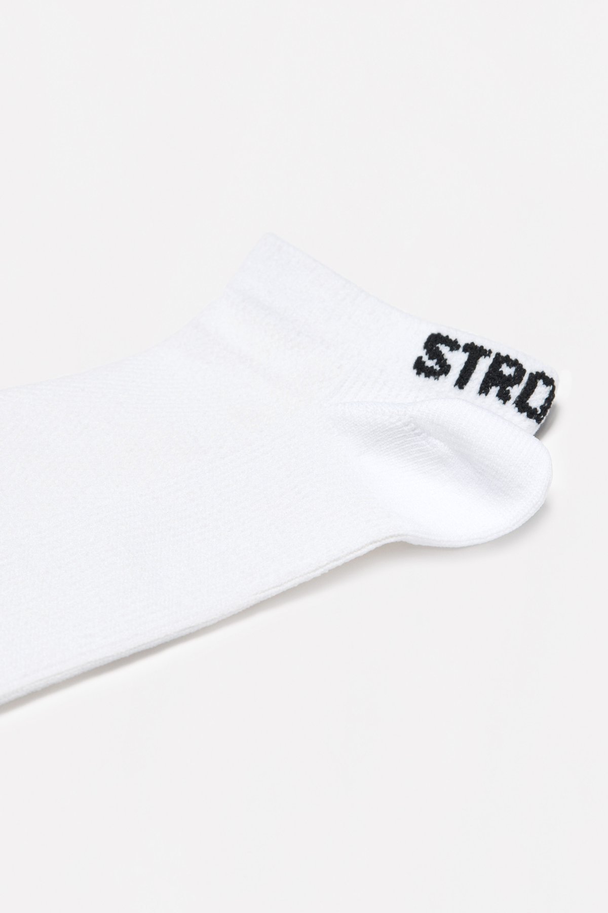 Close-up of the white Sporty Socks from stronger, showing the knitted ankle design and logotype at the back.