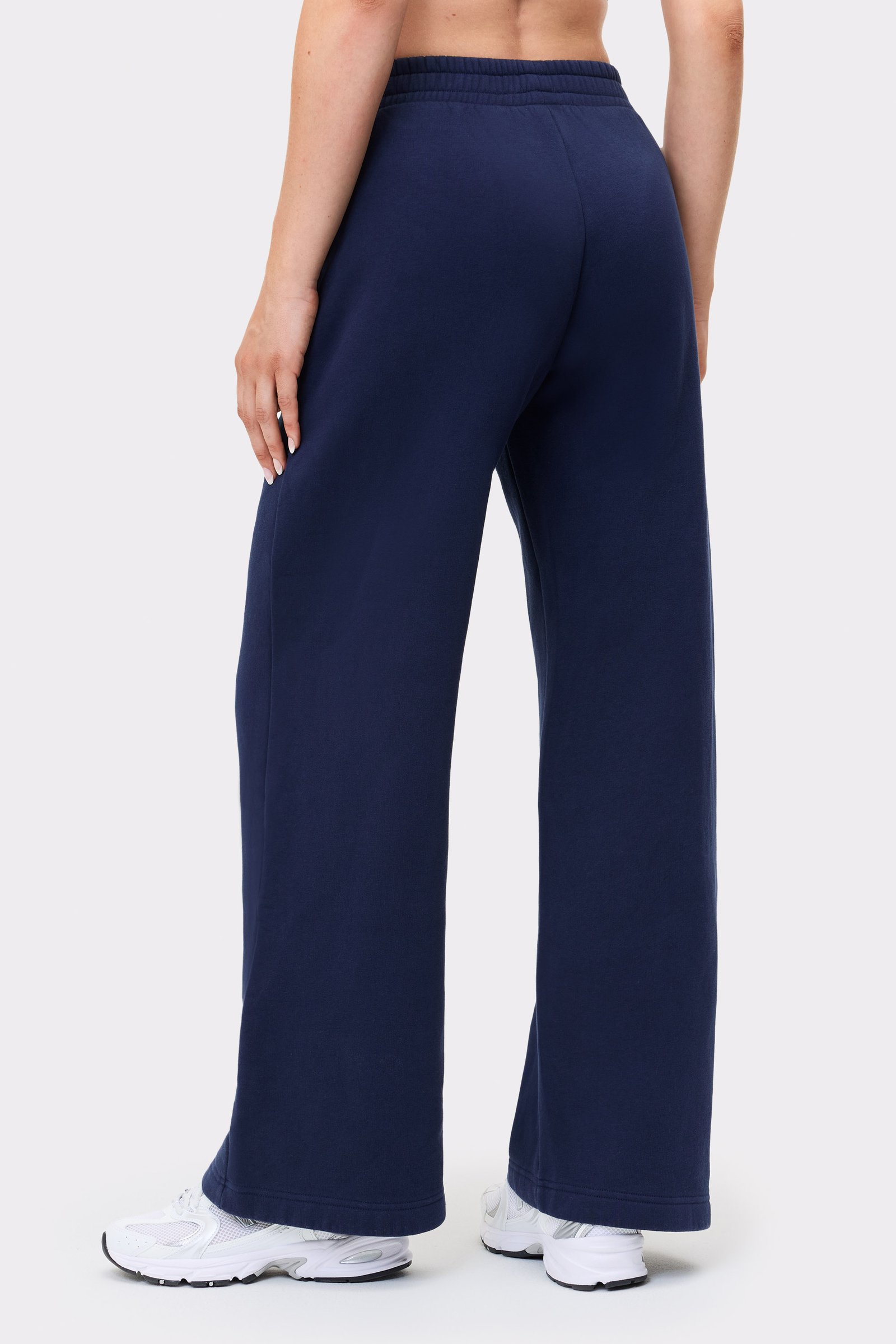 Rückansicht eines Models in den dunkelblauen Relaxed Wide Sweatpants von Stronger mit Oversize-Passform und geradem Bein.