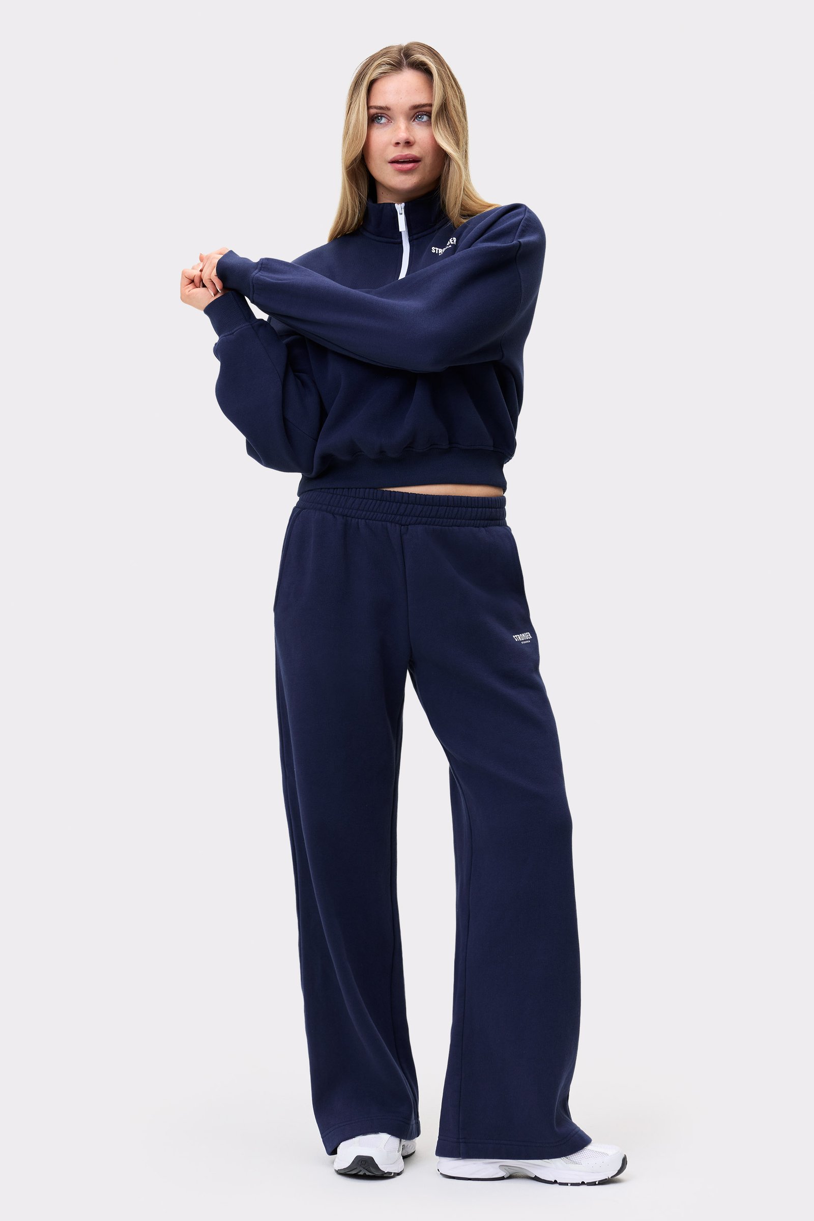 Ein Model in den dunkelblauen Relaxed Wide Sweatpants von Stronger und passendem Oberteil für einen bequemen Loungewear-Look.