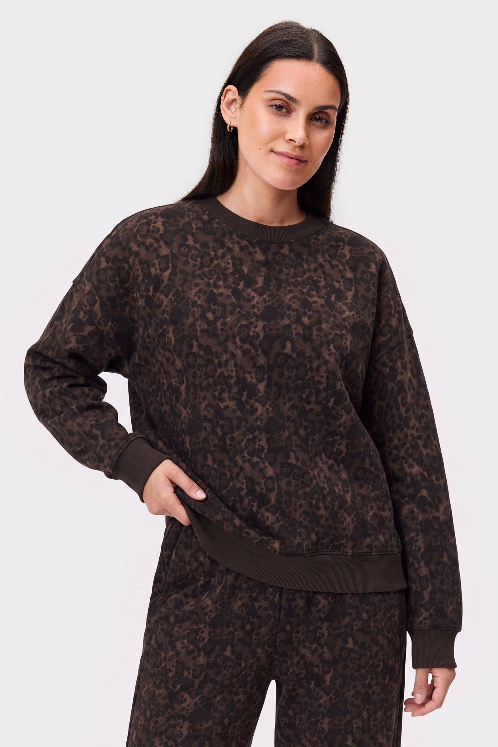 Model wearing the cozy Relaxed Sweatshirt in dark leopard print from stronger, showing an oversized fit and ribbed cuffs.