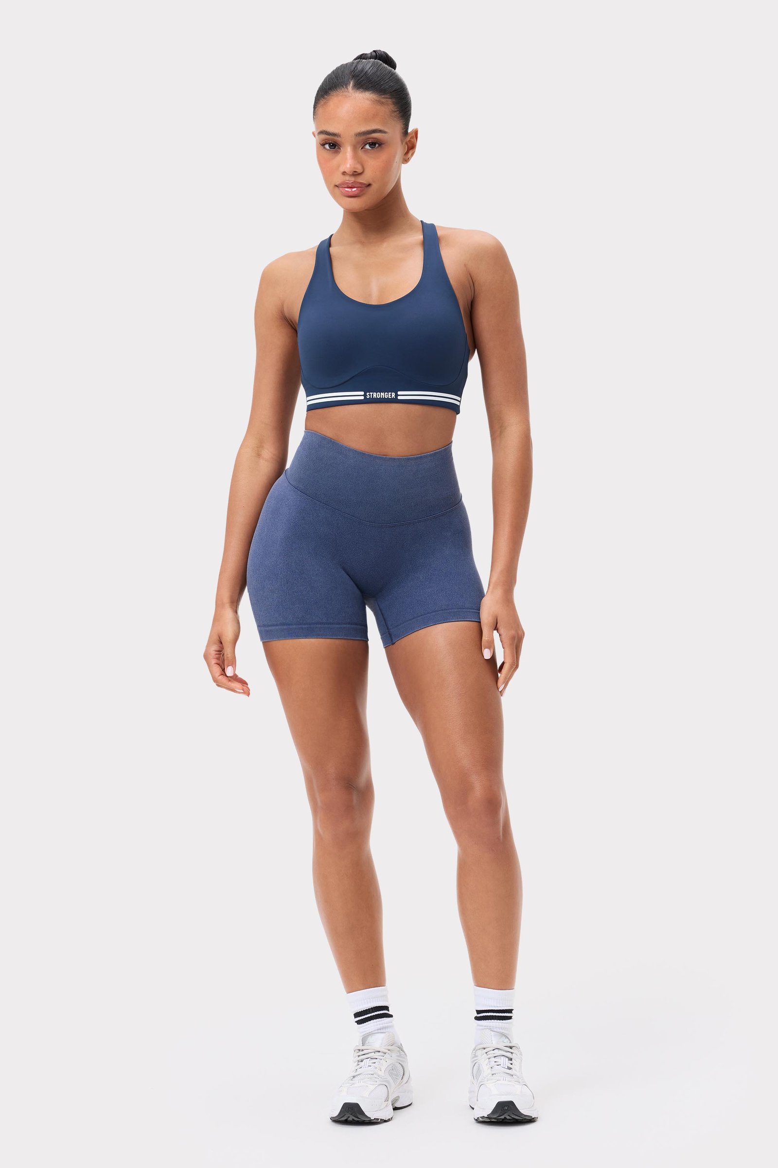 Model draagt de Navy Blazer Washed Seamless Shorts van Stronger met een hoge taille en een washed-out look.