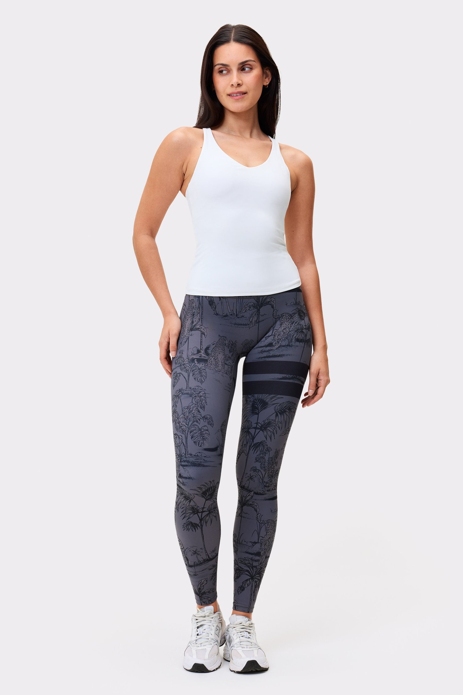 Ganzansicht eines Models in der The Signature One Leggings mit Dark Toile Print von Stronger und einem weißen Top.