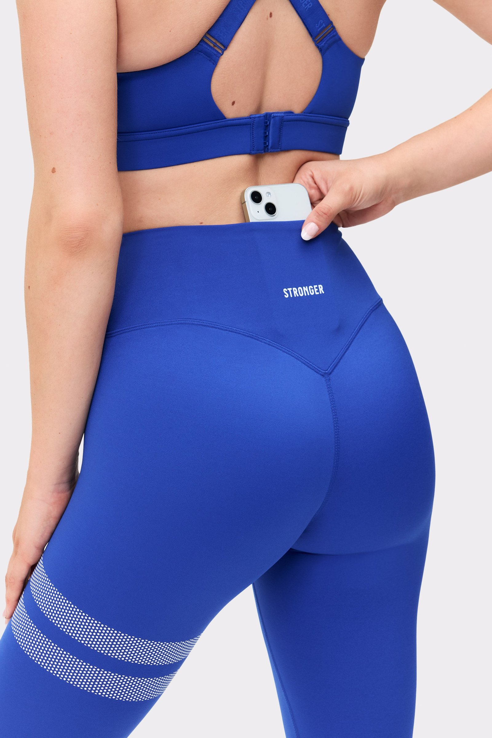Nahaufnahme der blauen The Signature One Leggings von Stronger mit Bundtasche hinten und zentriertem Logo.