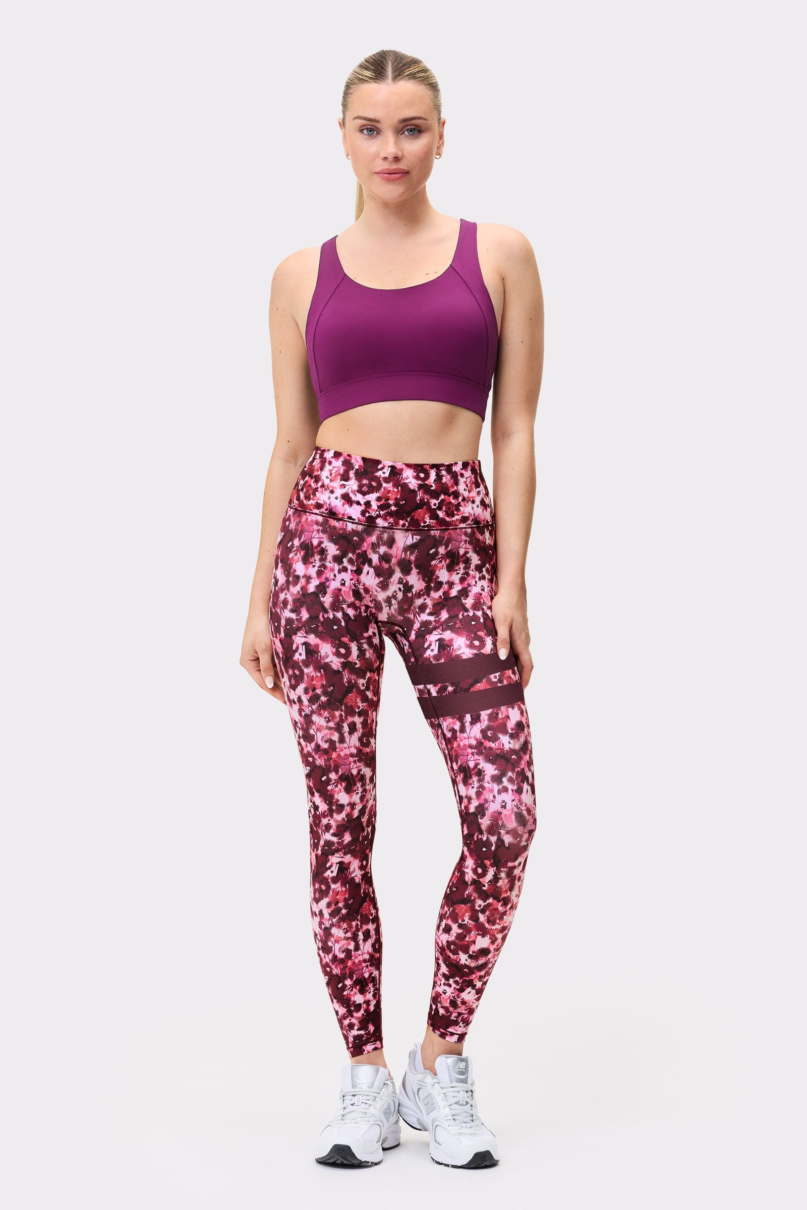 Front view of a model wearing Stronger The Signature One Leggings in Autumn Petals with signature stripes on the leg.