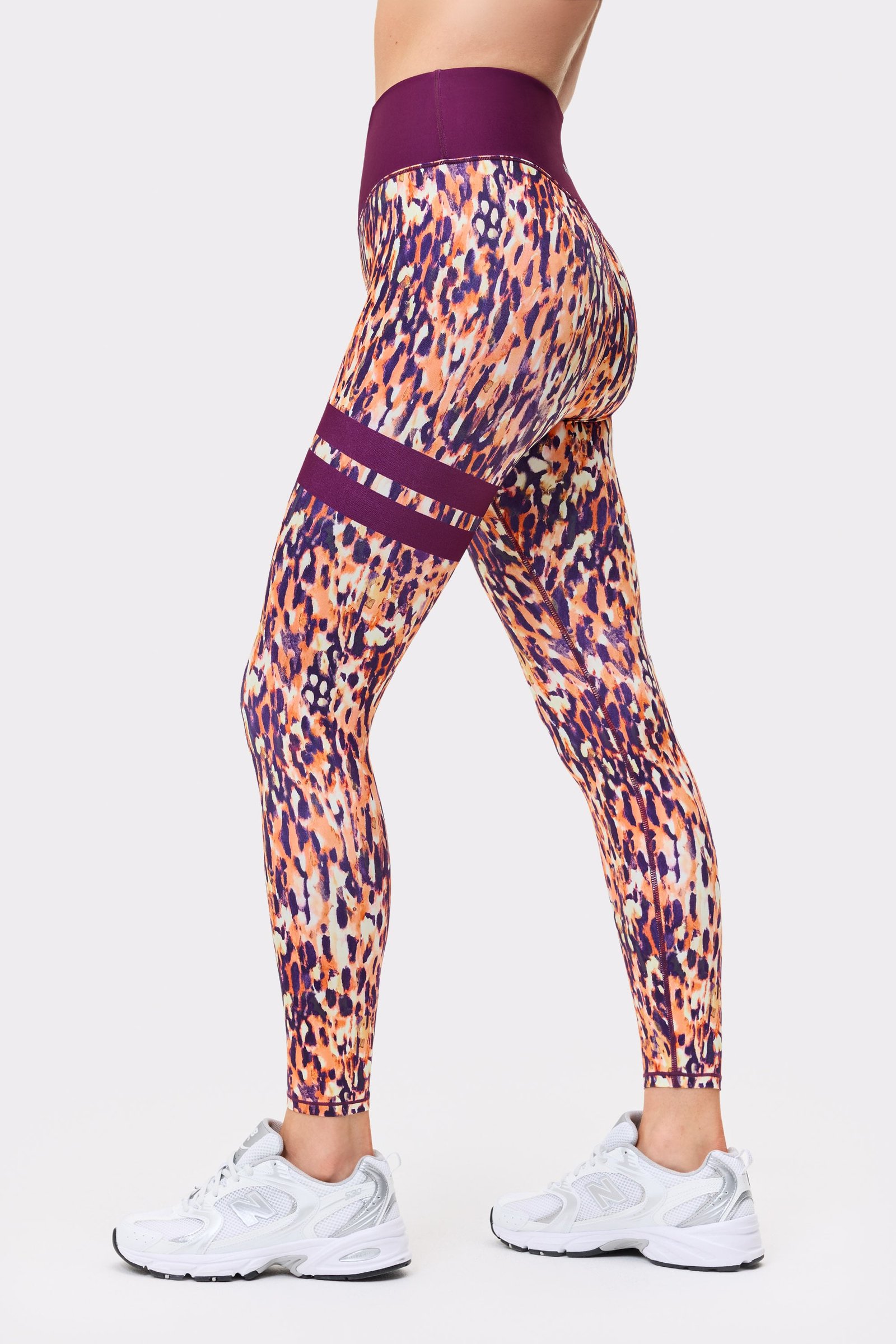 Side view of someone in Stronger The Signature One Leggings in Malibu Milk Print, showing signature lines.