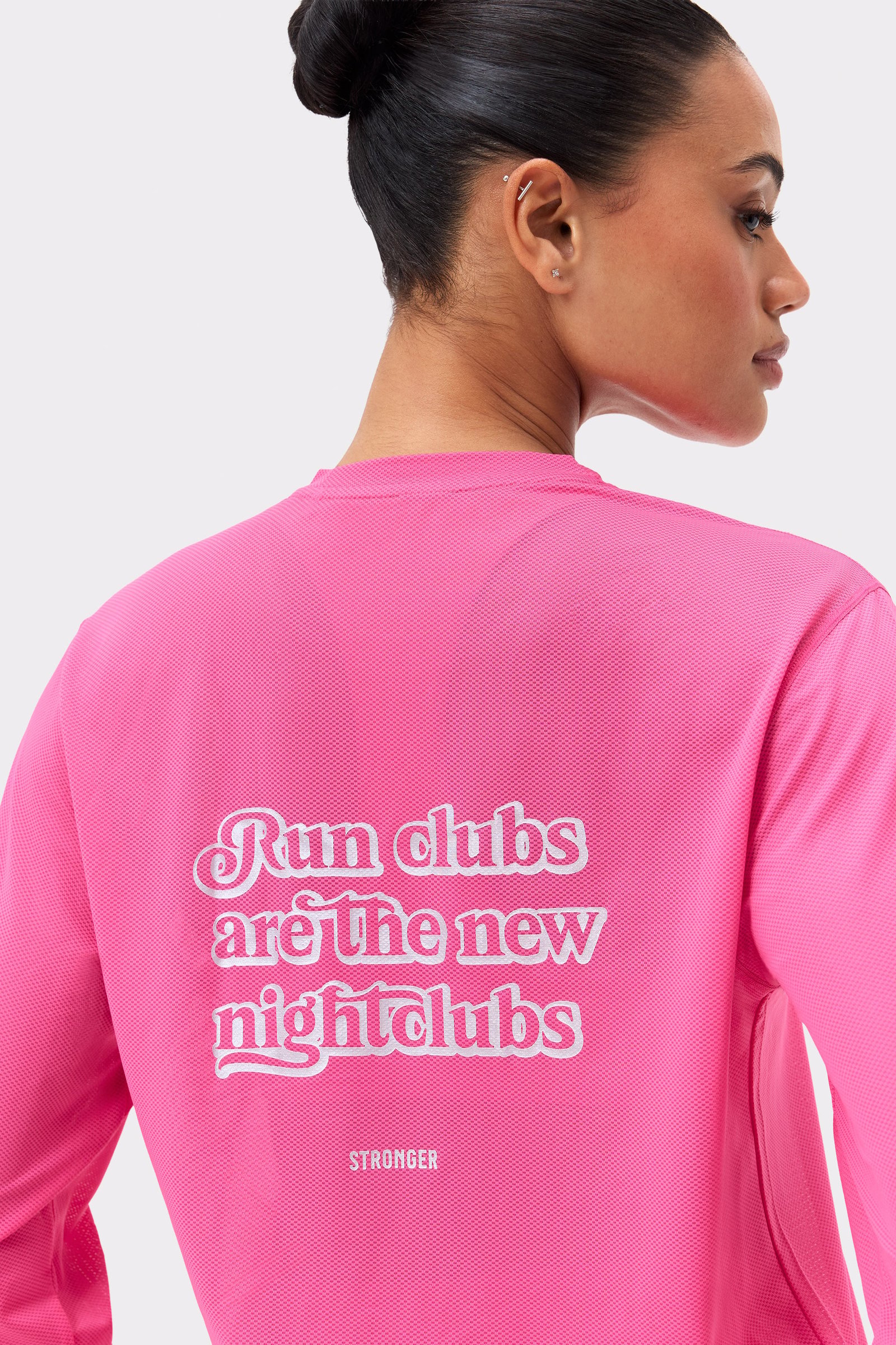 Pink Mesh Running Long Sleeve by Stronger, featuring a white 'Run clubs are the new nightclubs' graphic on the back.
