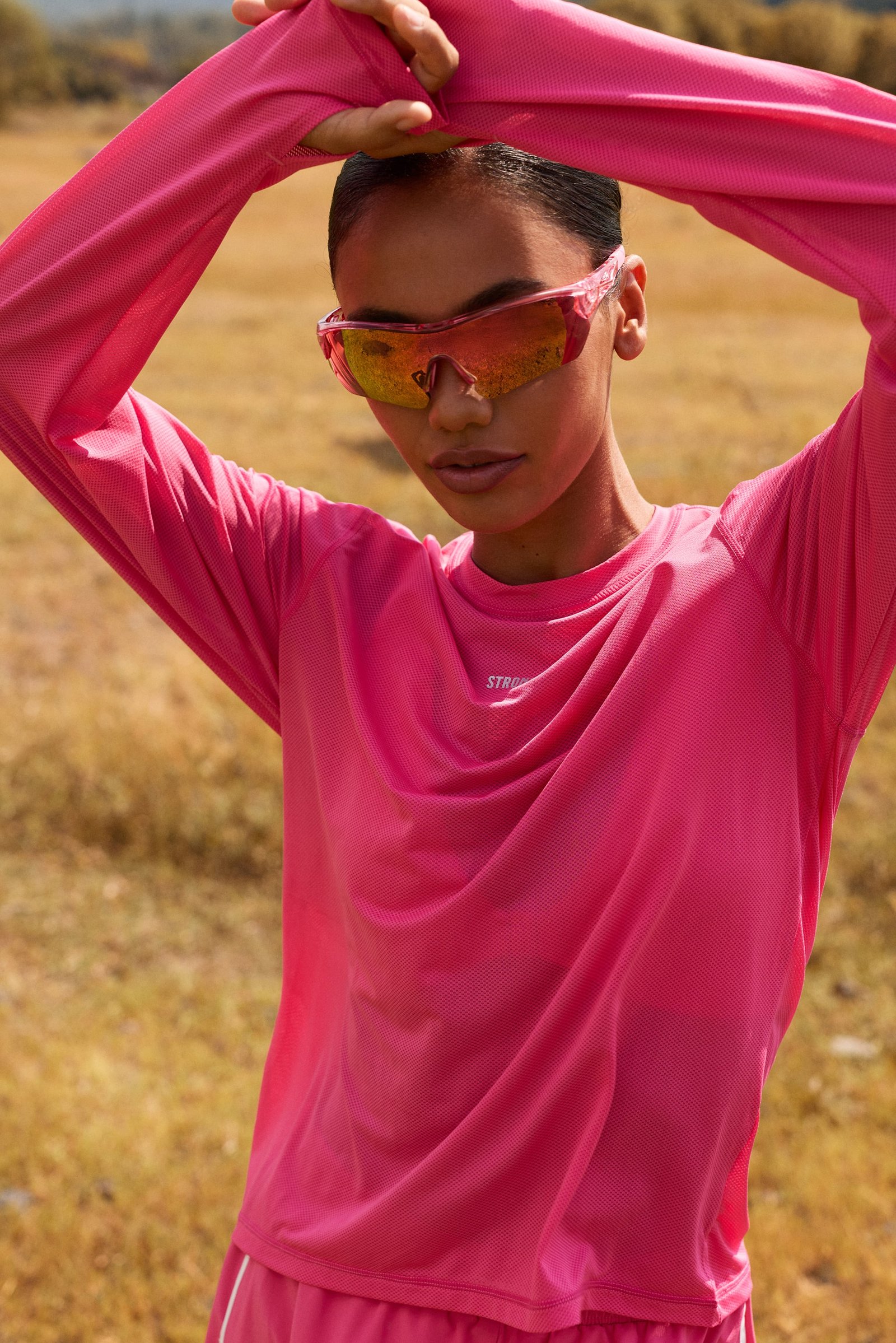 Pink Mesh Running Long Sleeve by Stronger, featuring breathable mesh fabric and a loose fit for outdoor training.