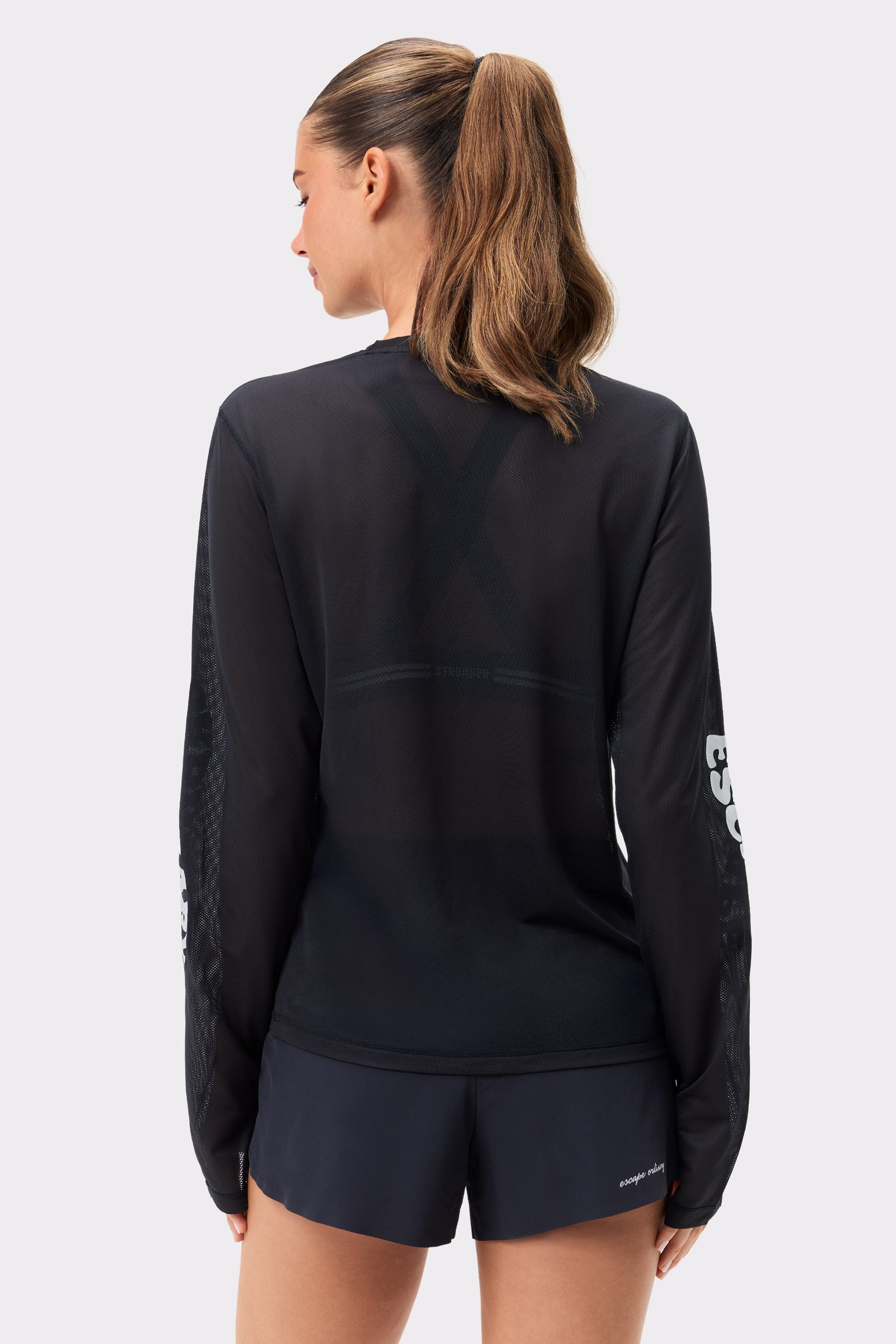 Back view of Stronger's black Mesh Running Long Sleeve, showcasing the breathable thin mesh and reflective back details.