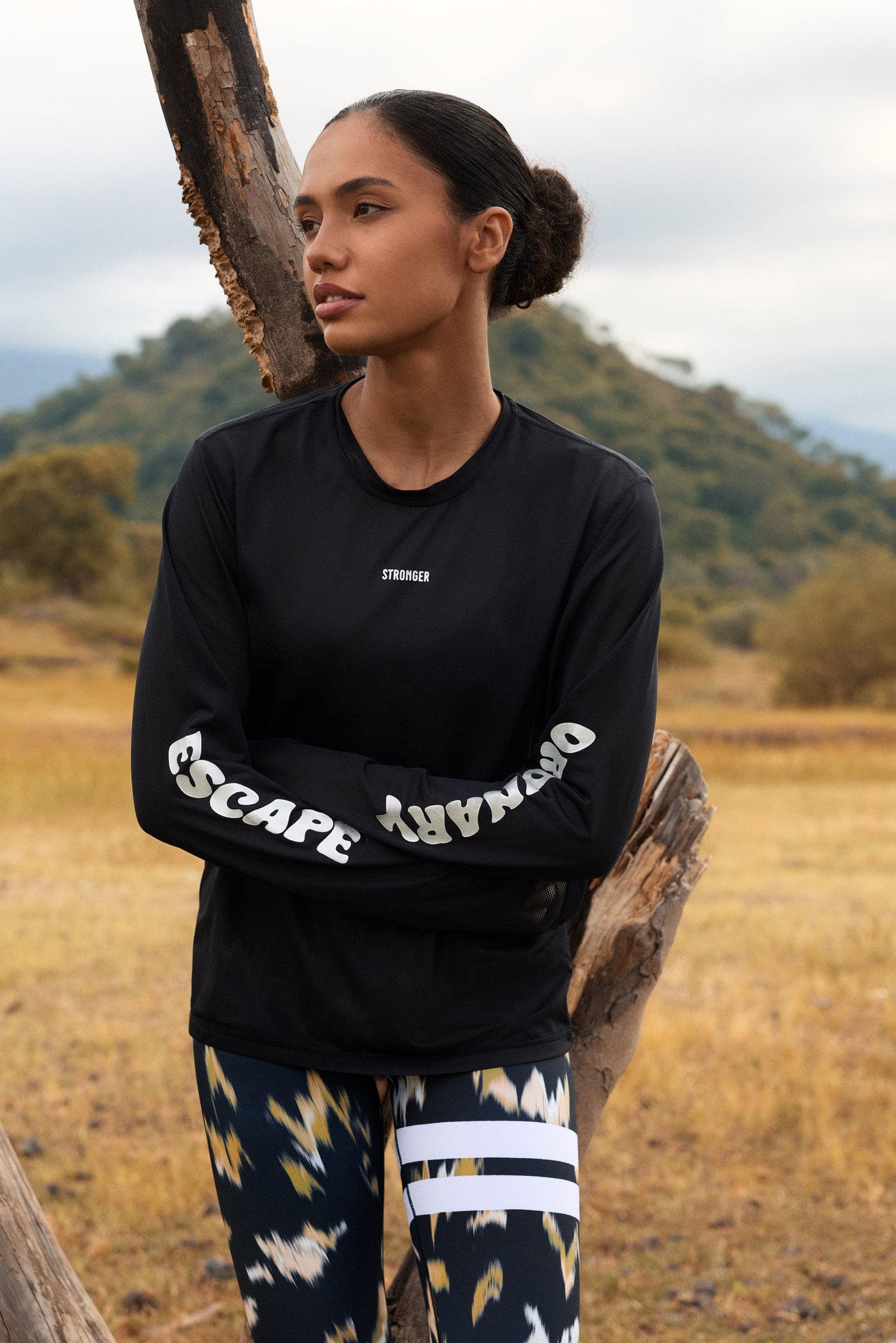 Black Mesh Running Long Sleeve by Stronger with reflective 'Escape Ordinary' sleeve graphics and a loose fit.