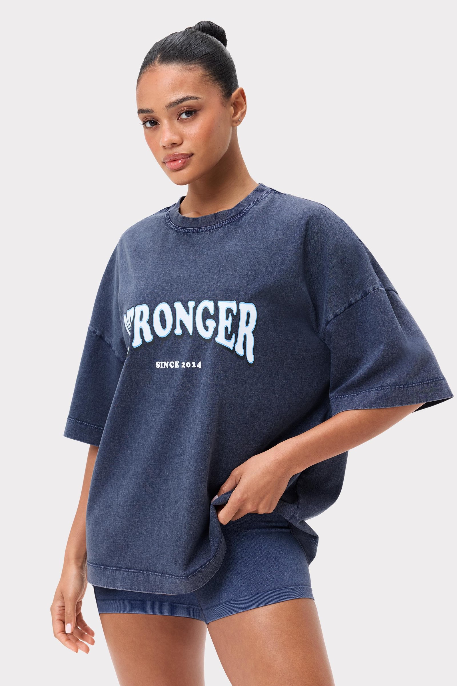 Model in het washed out Navy Blazer Oversized Crew T-shirt van Stronger met een geprint logo op de borst.