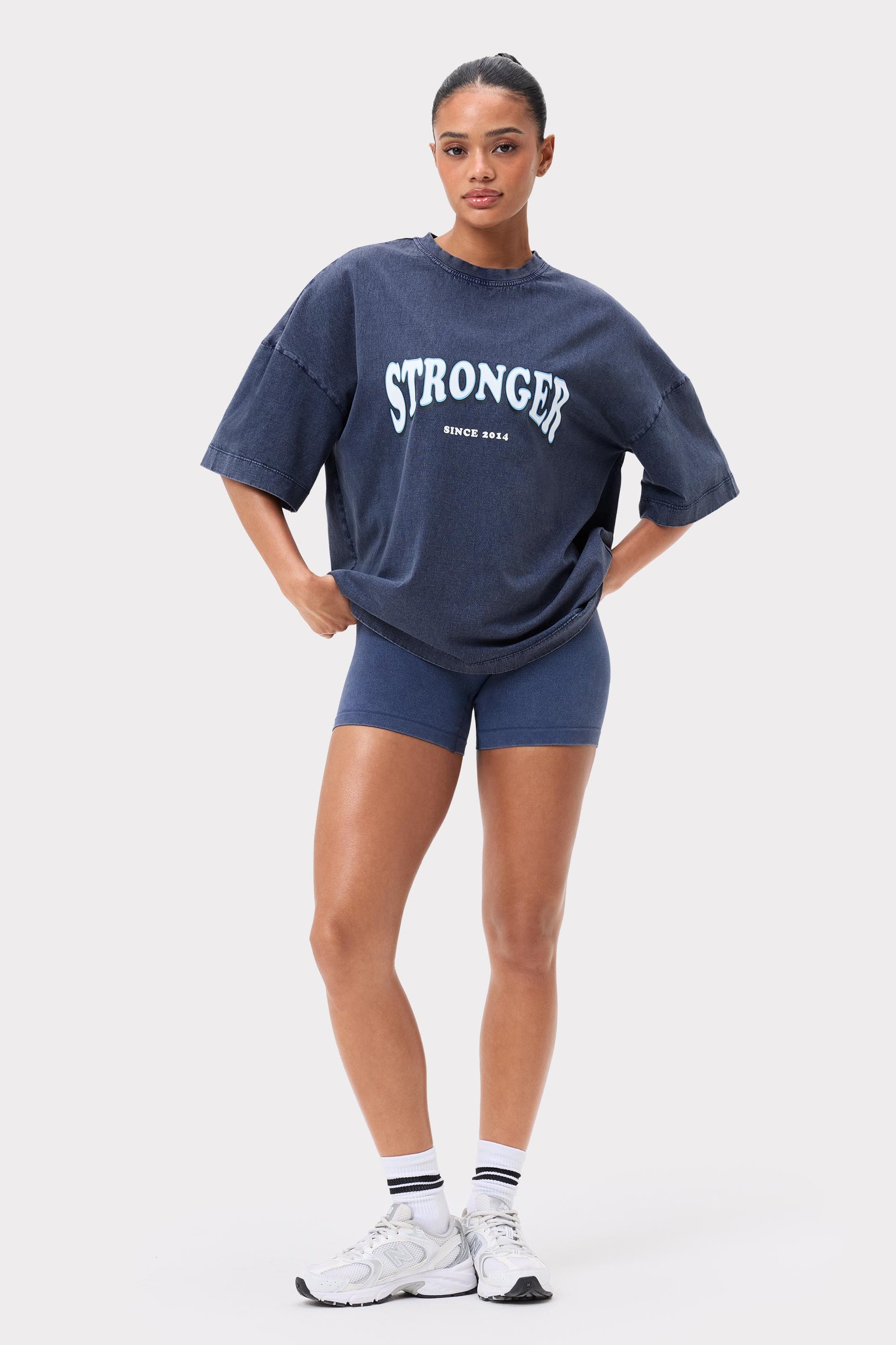 Model draagt het Navy Blazer Oversized Crew T-shirt van Stronger met een gewassen look en een groot logo.