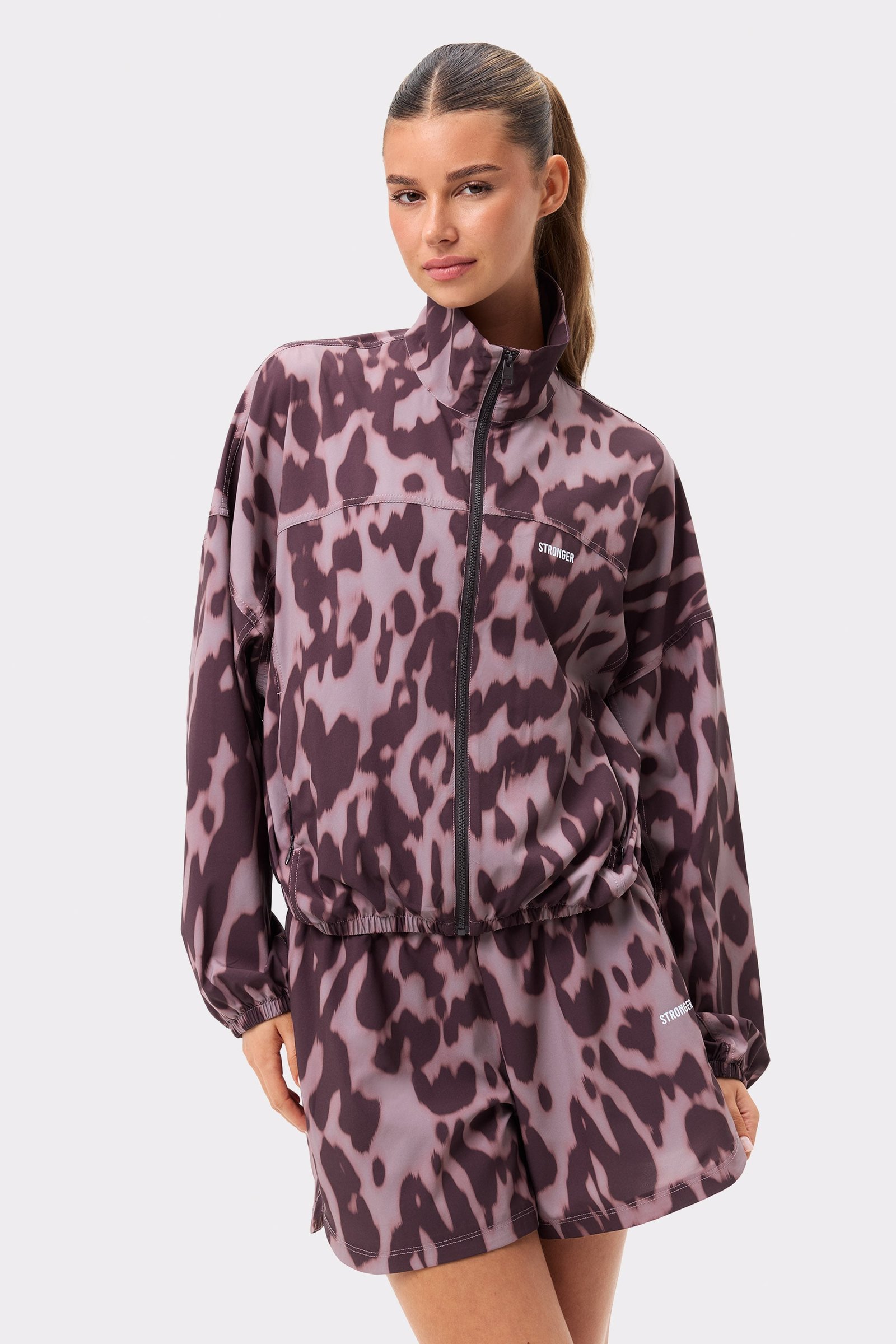 Model draagt de Stronger Breezy Woven Jacket in Leo Rush-print, een jack met luipaardmotief, losse pasvorm en hoge kraag.