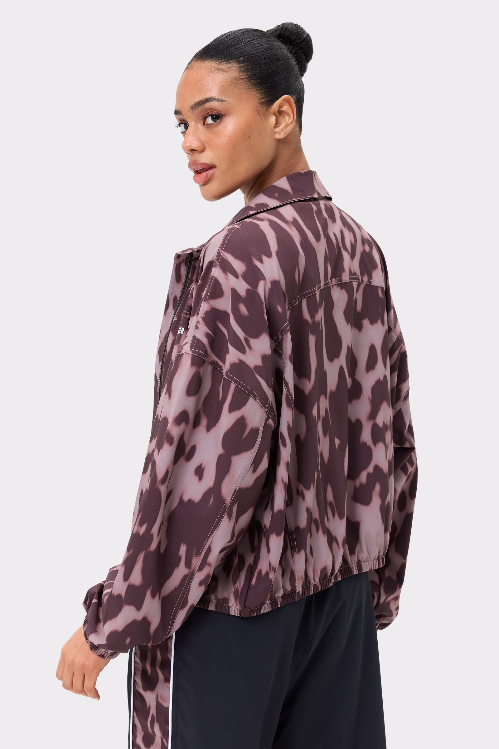 Zijaanzicht van de Breezy Woven Jacket van Stronger in Leo Rush-print, met een losse pasvorm en geweven stof met patroon.