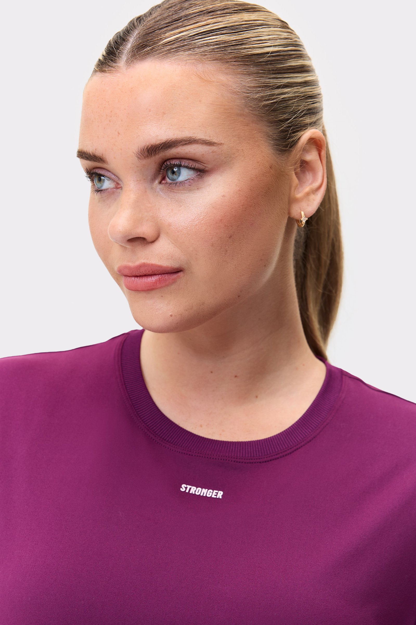 Close-up of a model wearing the aubergine purple Relaxed Tee from stronger, showing the soft fabric and neckline.