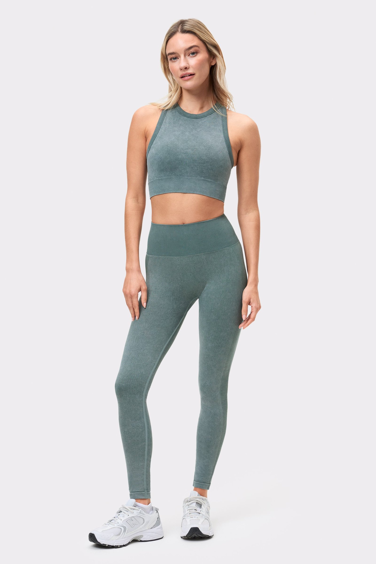 Vorderansicht eines Models, das den Silver Pine Washed seamless high neck bra und passende Leggings von Stronger trägt.