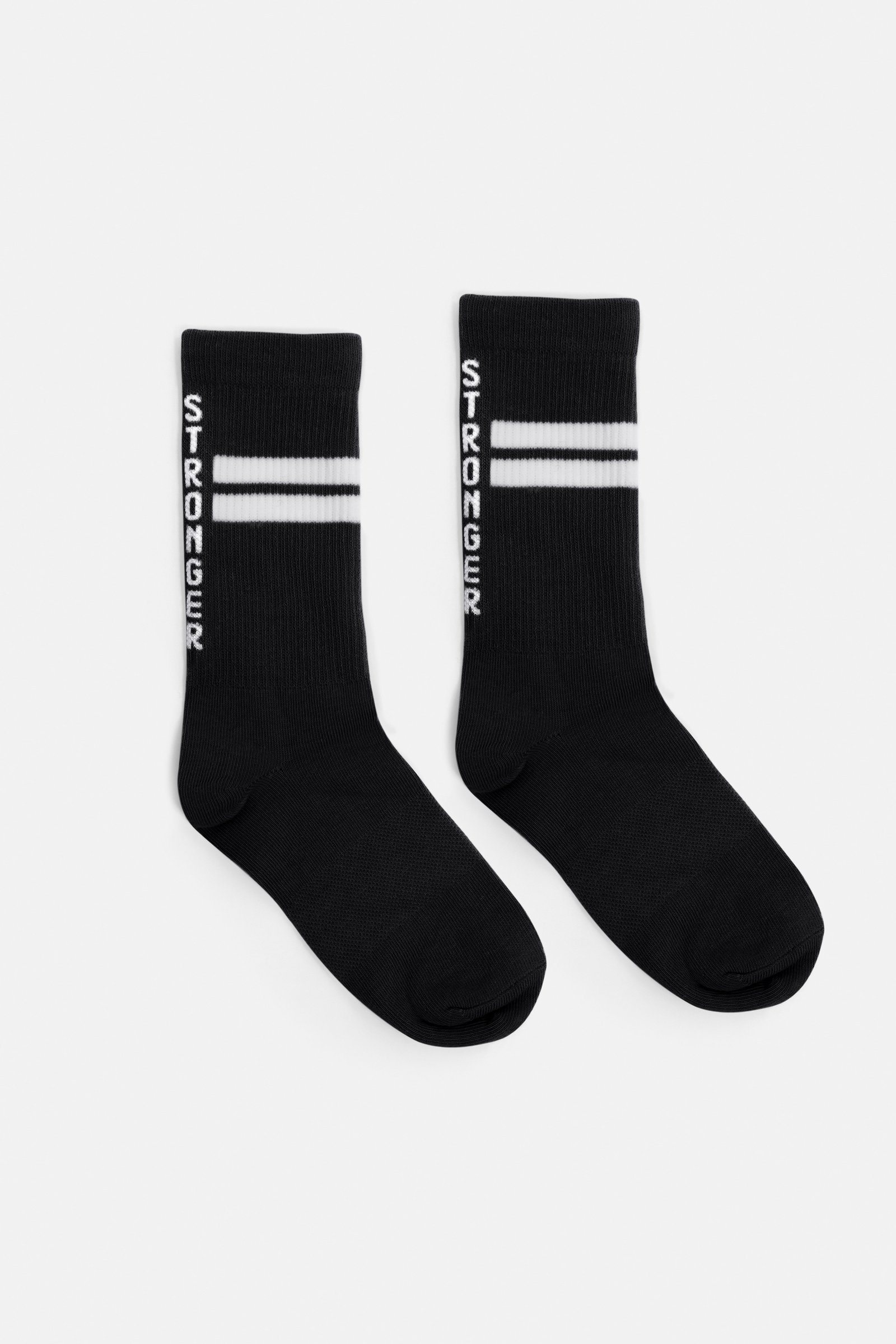 Schwarze Stride Socks von Stronger mit weißen Signature Lines und vertikalem Logotyp auf den gerippten Bündchen.
