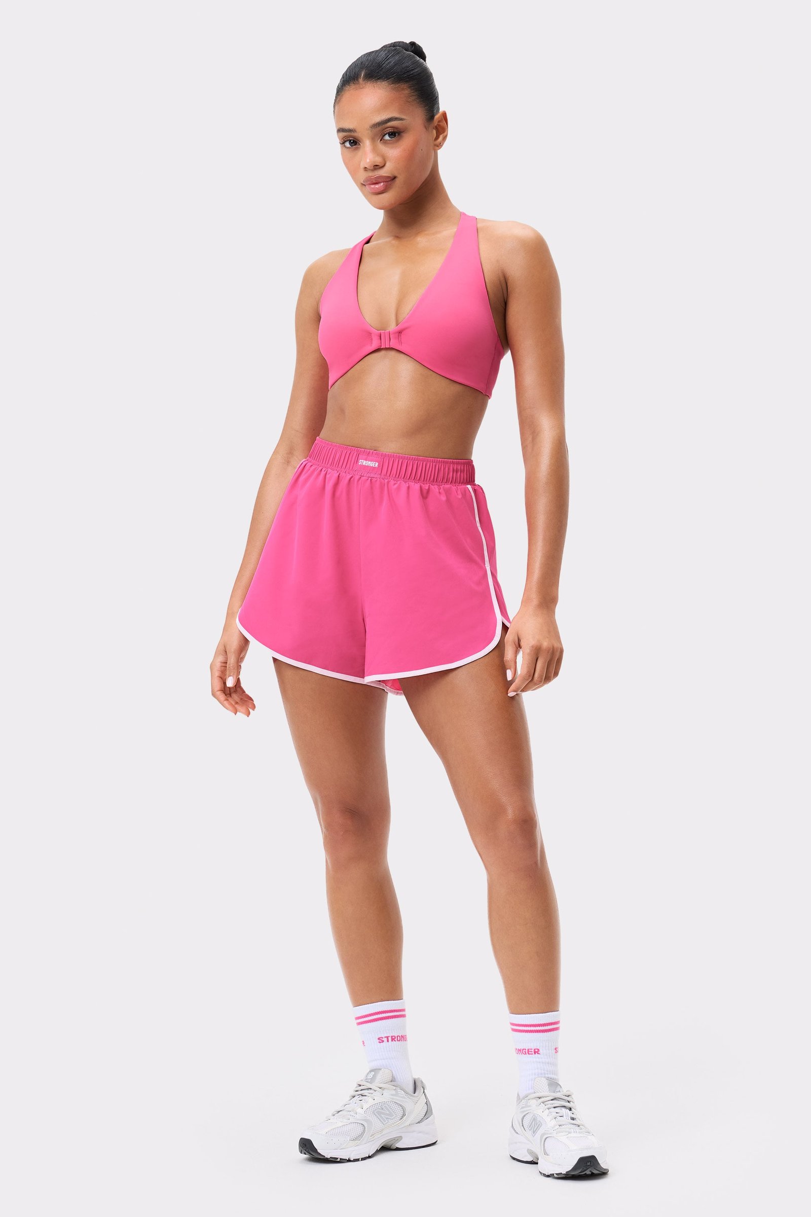 Essential Socks 2-pack in white with pink stripes, worn with a matching pink Stronger activewear set.