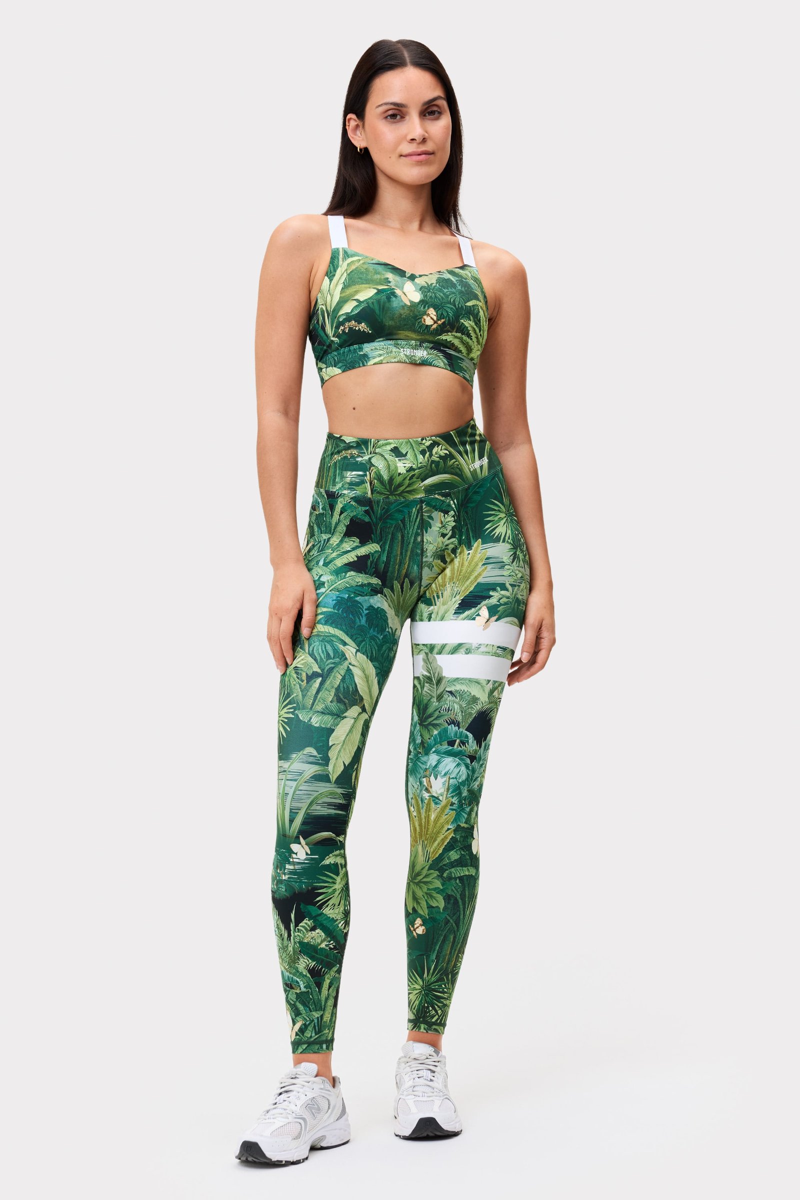 Model in Stronger Explore Printed Leggings mit Tropical Leaves Print, hoher Taille und charakteristischen Streifen.