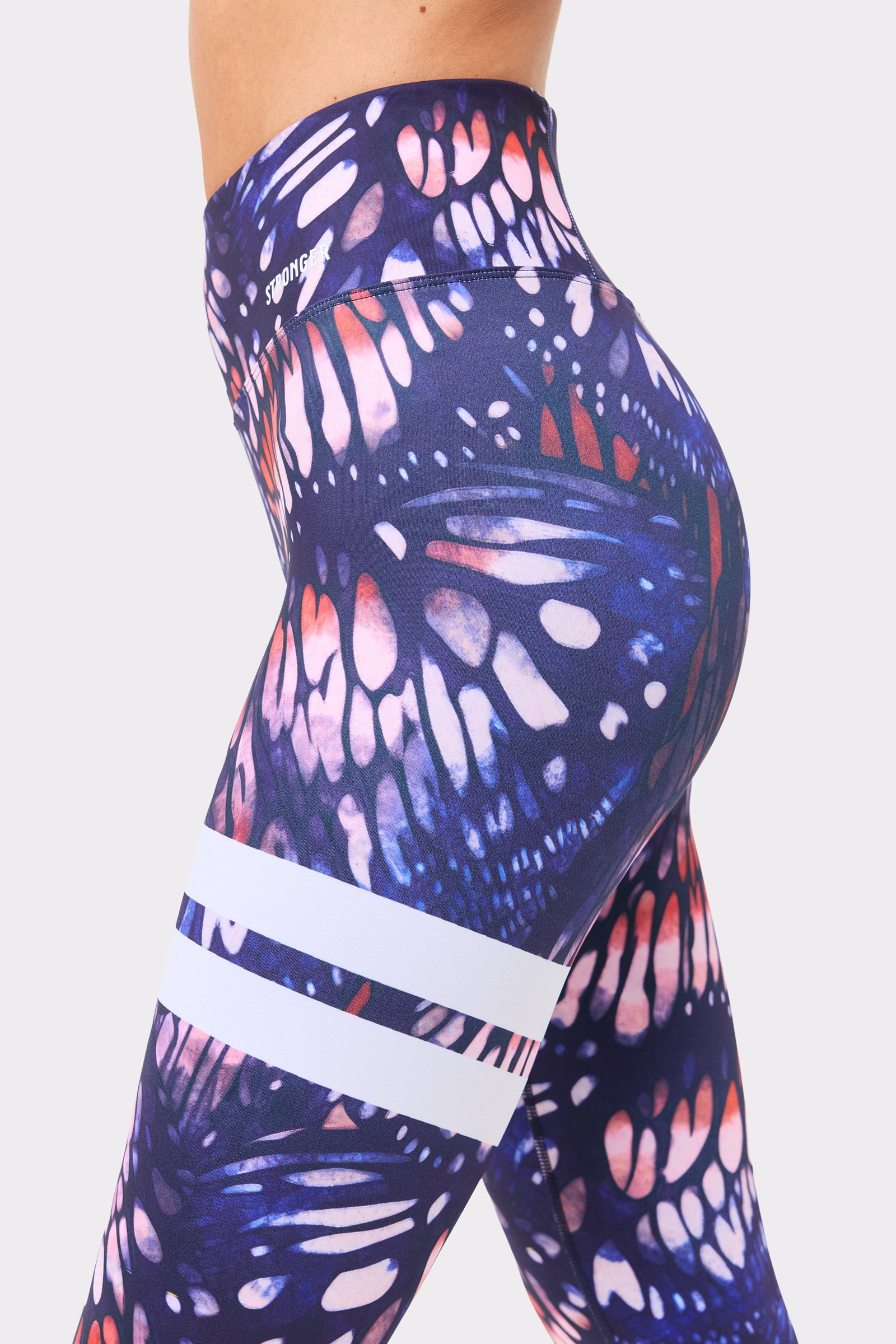 Side view of Stronger's Explore Printed Leggings in dark pink butterfly print, featuring signature white stripes.