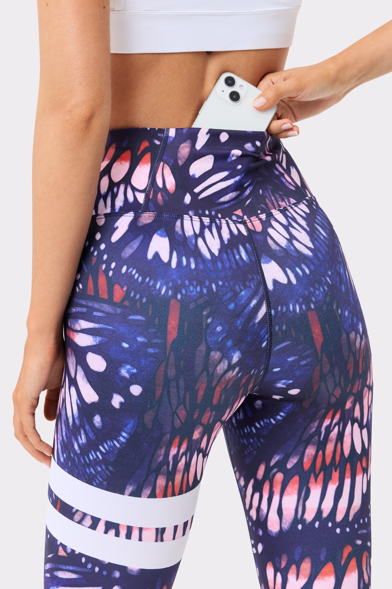 Back view of Stronger's high-waisted pink Explore Printed Leggings in Dark Butterfly print, with a back waistband pocket.