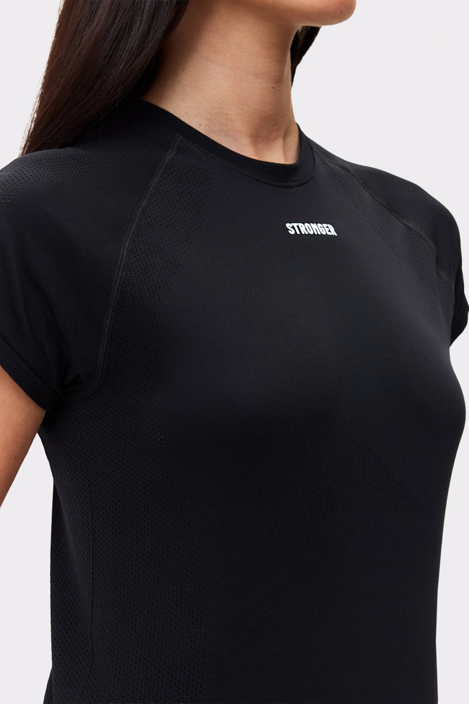 Close-up of the black Seamless Performance T-shirt by Stronger, featuring breathable mesh texture and chest logo.
