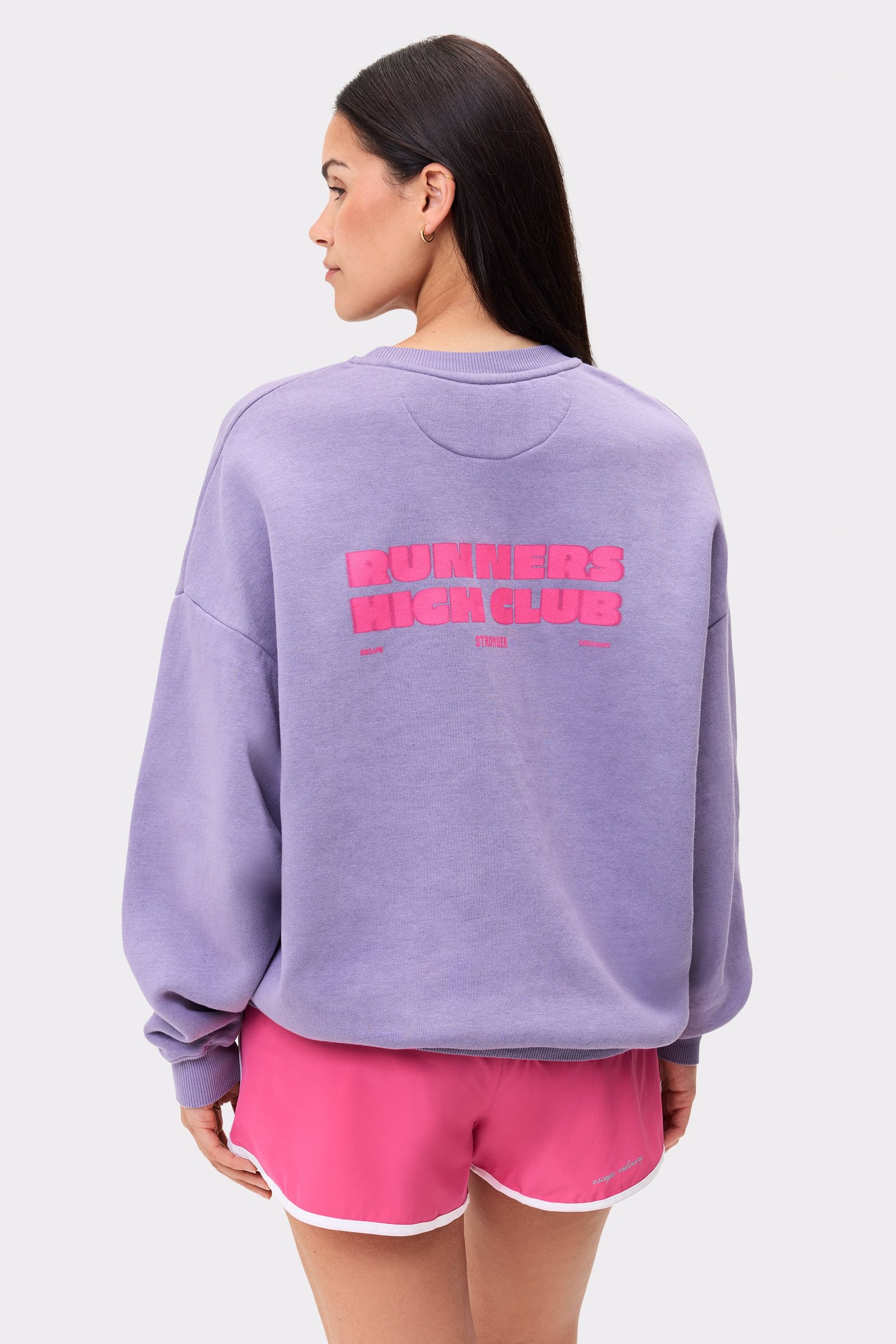 Oversized Stronger Comfy Washed Sweatshirt in vintage violet, featuring a pink Runners High Club back graphic.