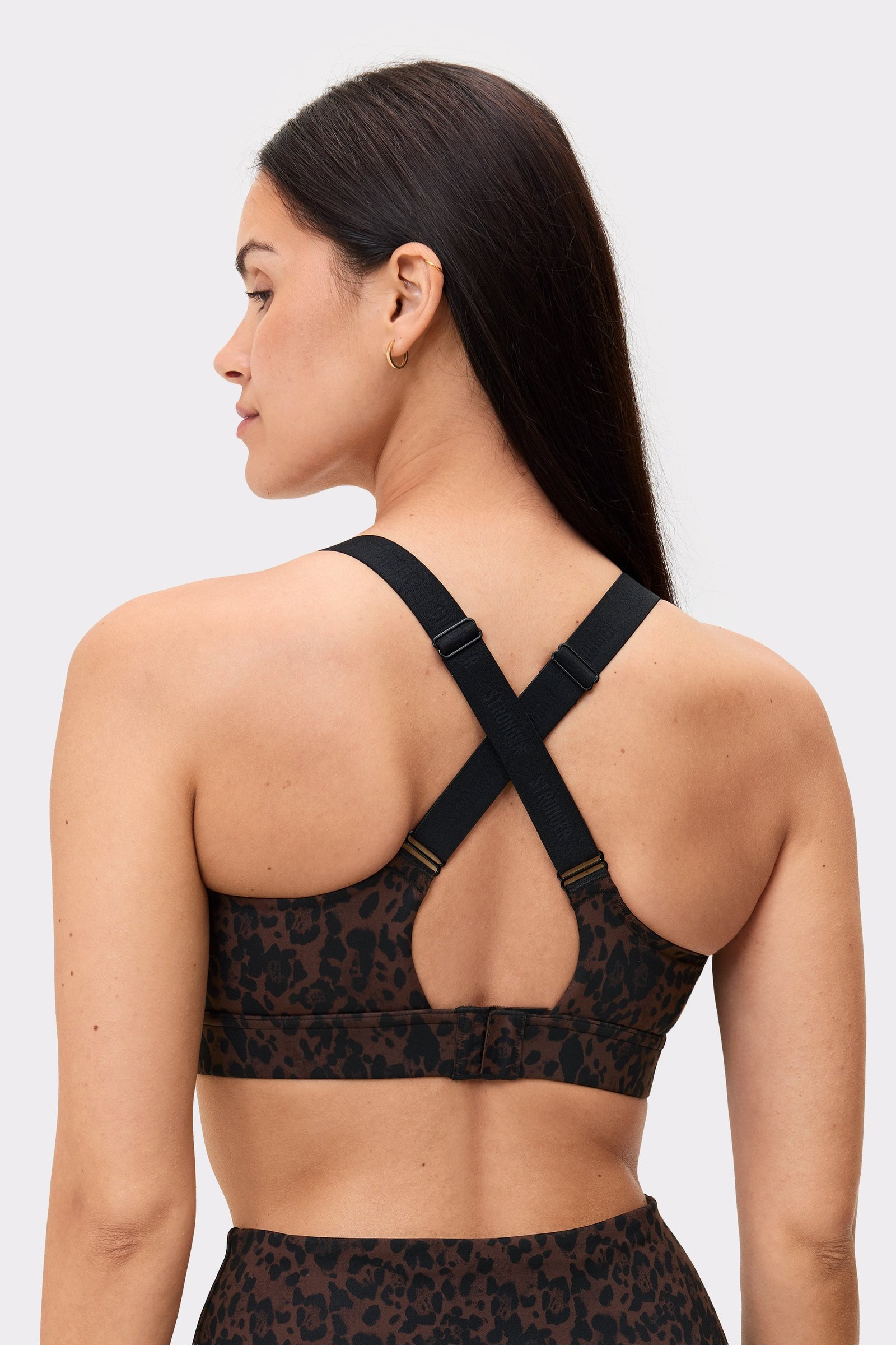 Back view of a model wearing the Power Sports Bra in Dark Leo by stronger, showing the adjustable straps.