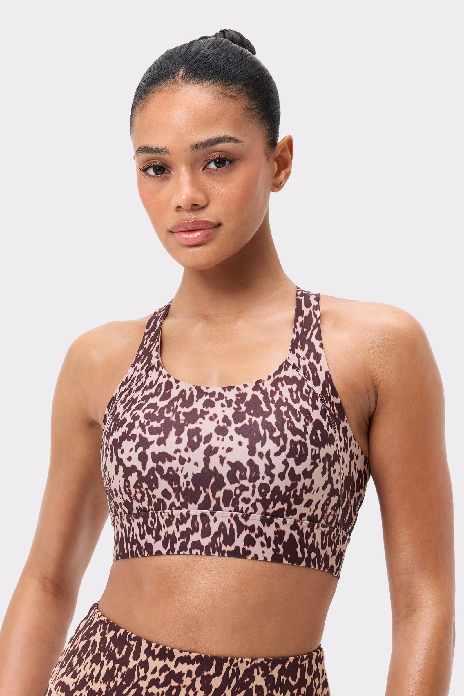 Front view of the Stronger Bounce Sports Bra in light brown Leo Rush print, featuring wide straps and high support.