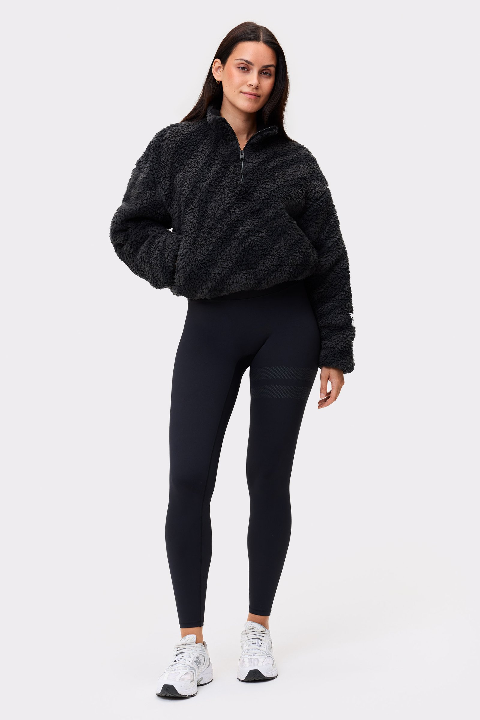 Model im schwarzen Zebra Pile Half Zip von Stronger, einer kuscheligen Fleece-Schicht mit Half-Zip und hohem Kragen.