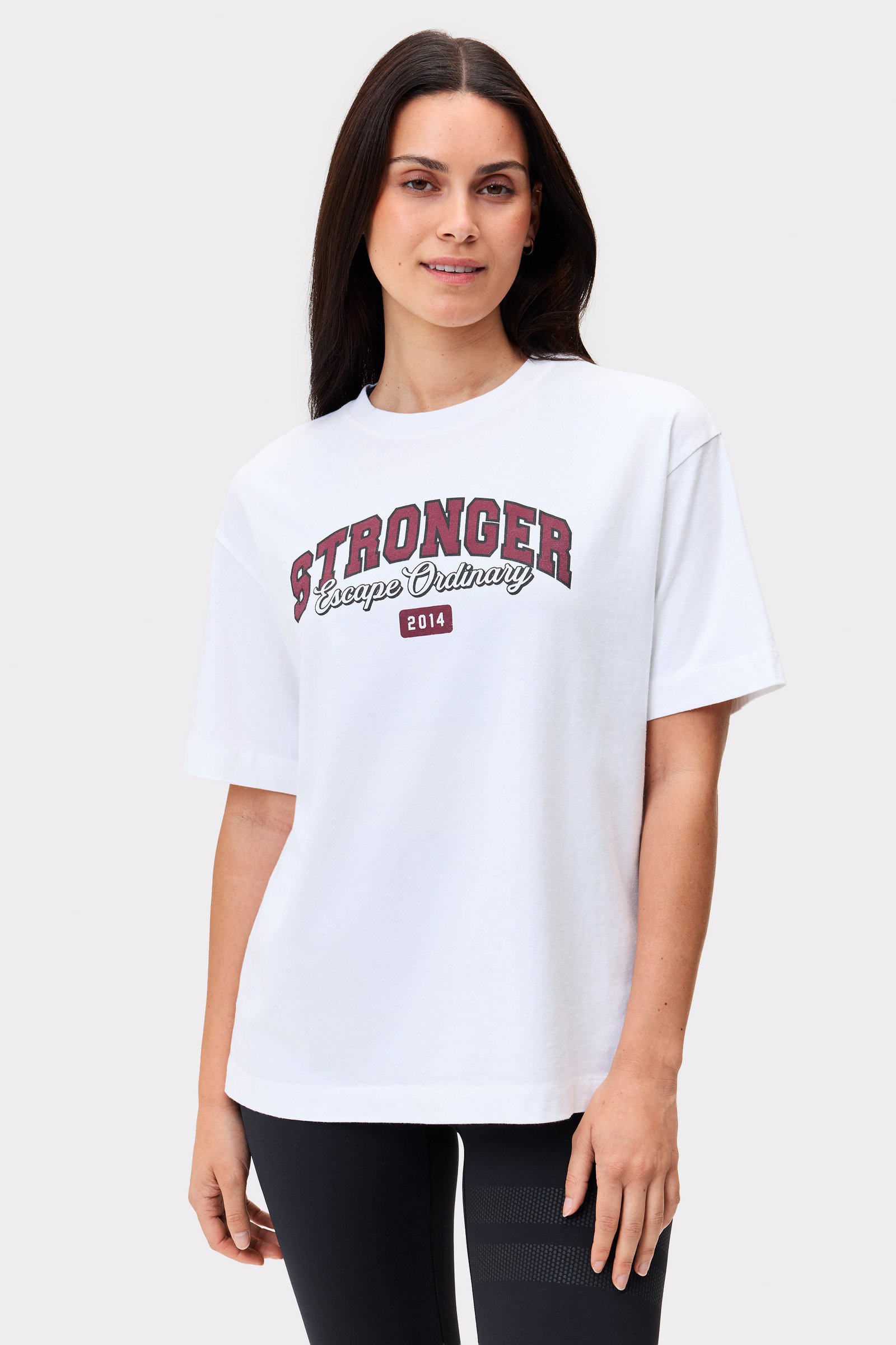 Model in dem hellen weißen Essential T-shirt von Stronger im Regular Fit mit auffälligem Grafikprint auf der Vorderseite.