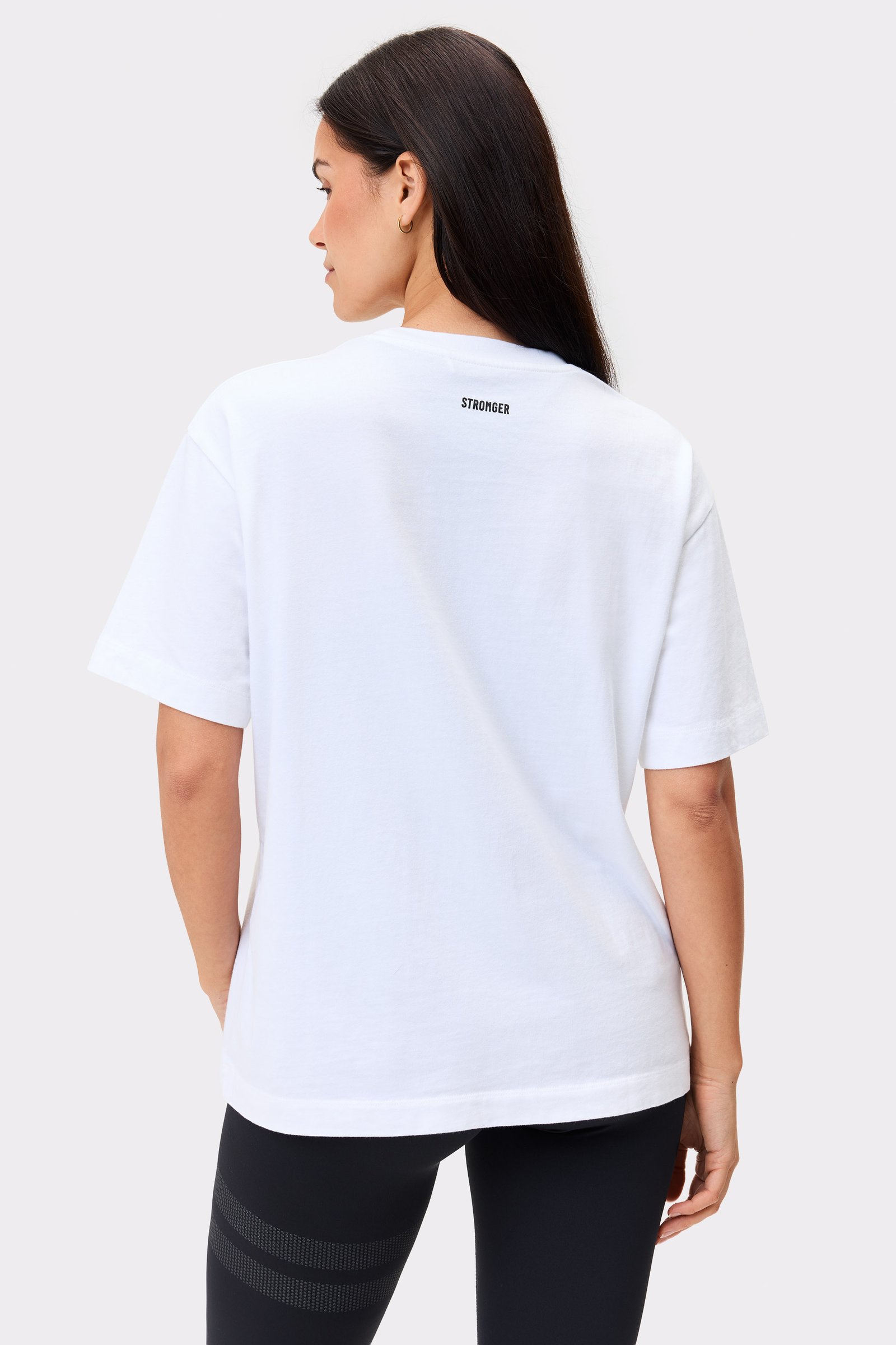 Rückansicht eines Models im weißen Essential T-shirt von Stronger mit normaler Passform und Bio-Baumwolle.