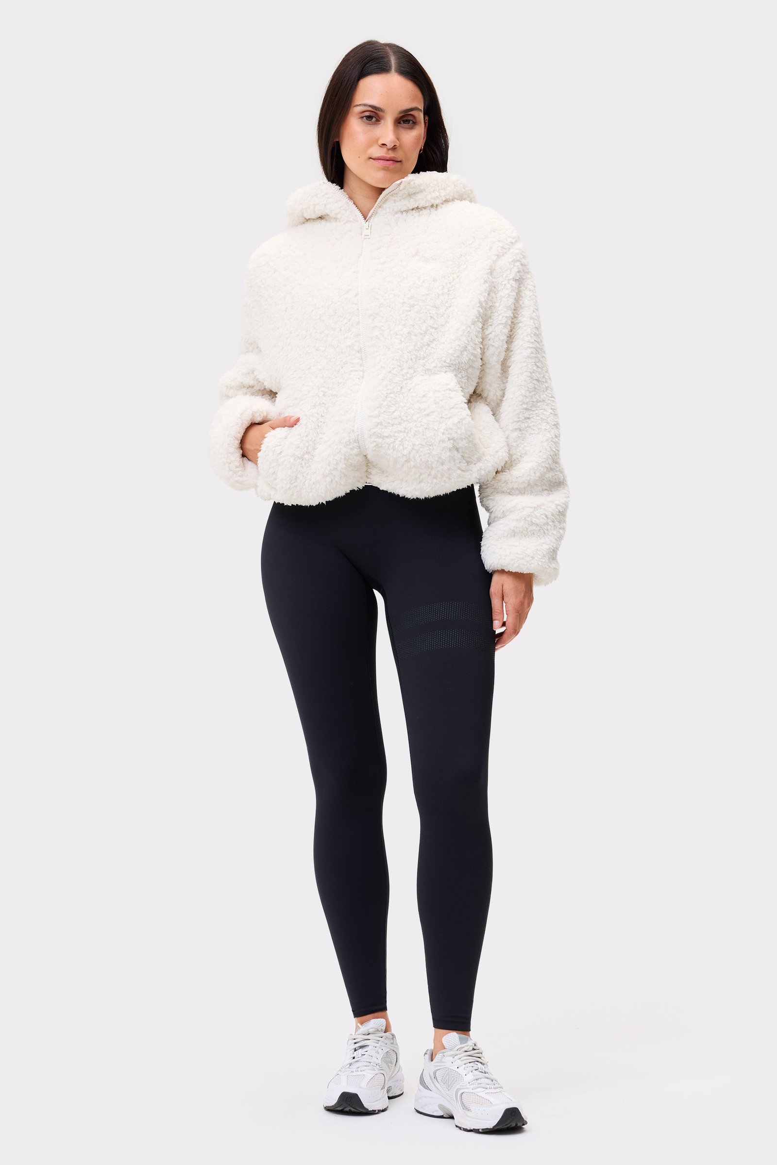 Model trägt die weiße Hooded Pile Jacket von Stronger aus recyceltem Polyester für gemütliche Freizeitkleidung.