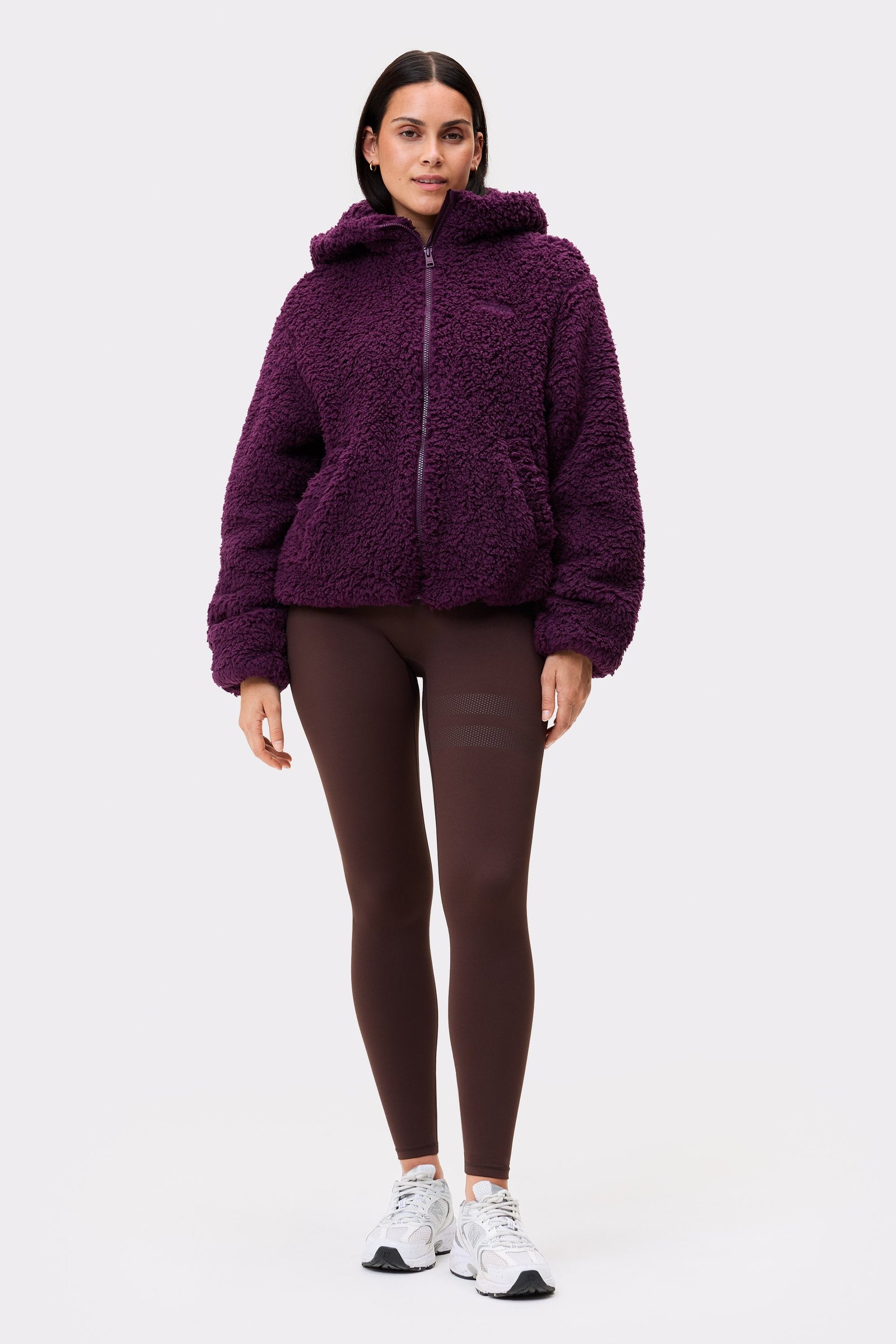Front view of a model wearing the dark purple Hooded Pile Jacket from stronger with a soft texture and regular fit.