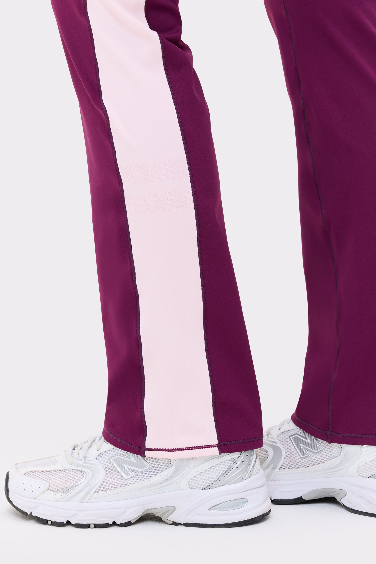 Close-up of the side panel on the Thermal Bootcut Pants in aubergine purple from stronger, showing the light pink stripe.