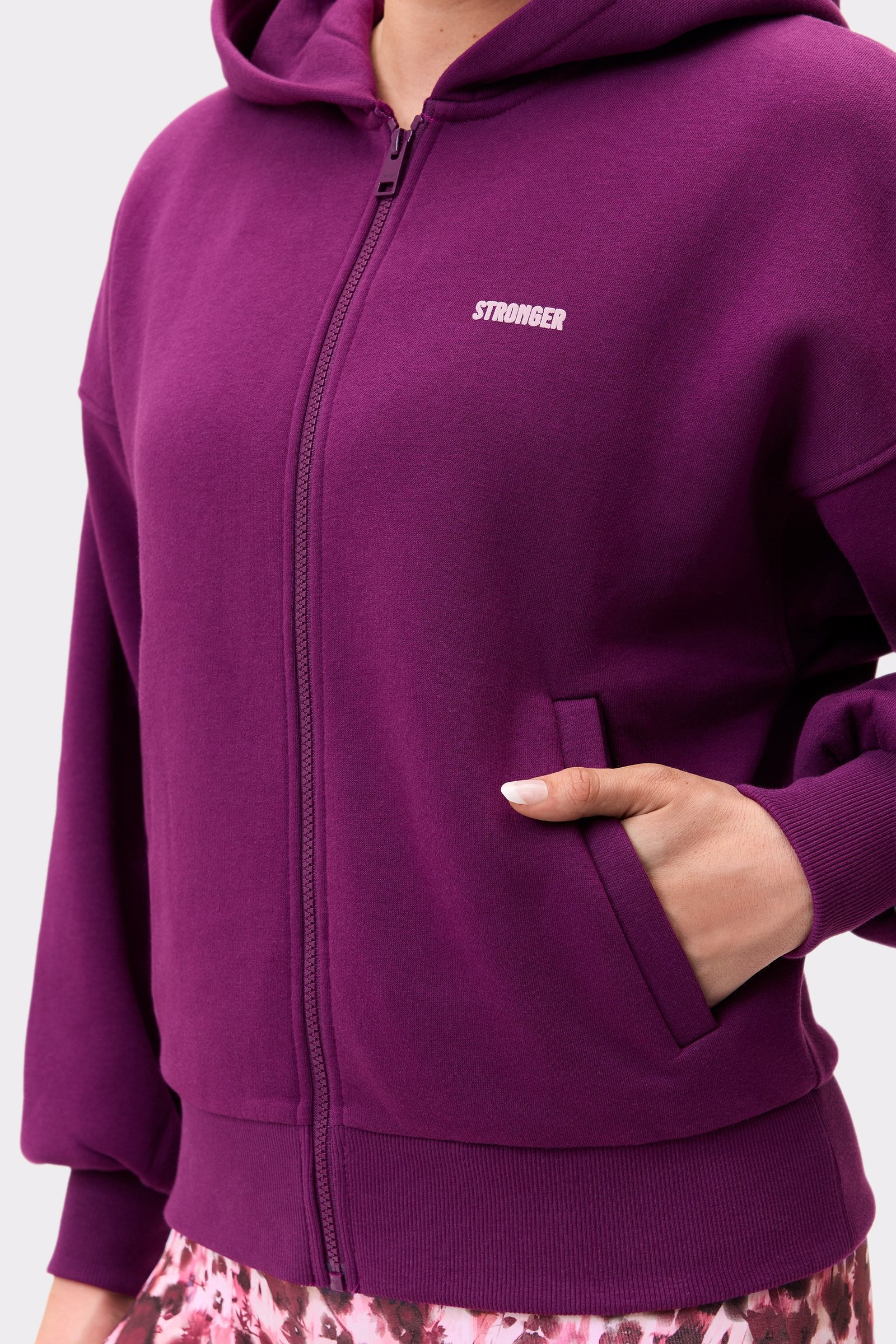 Close-up of the stronger Relaxed Full Zip Hoodie in aubergine purple, showing the pocket and logotype on the right chest.