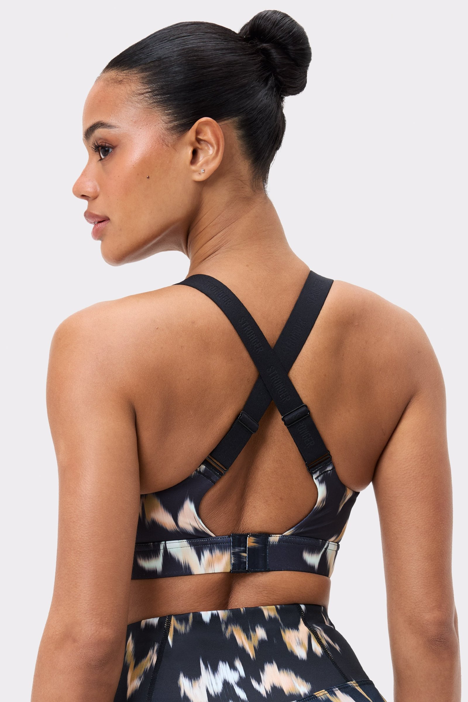 Back view of Stronger's Power Sports Bra in Savannah Print, featuring adjustable cross-back straps and hook closure.