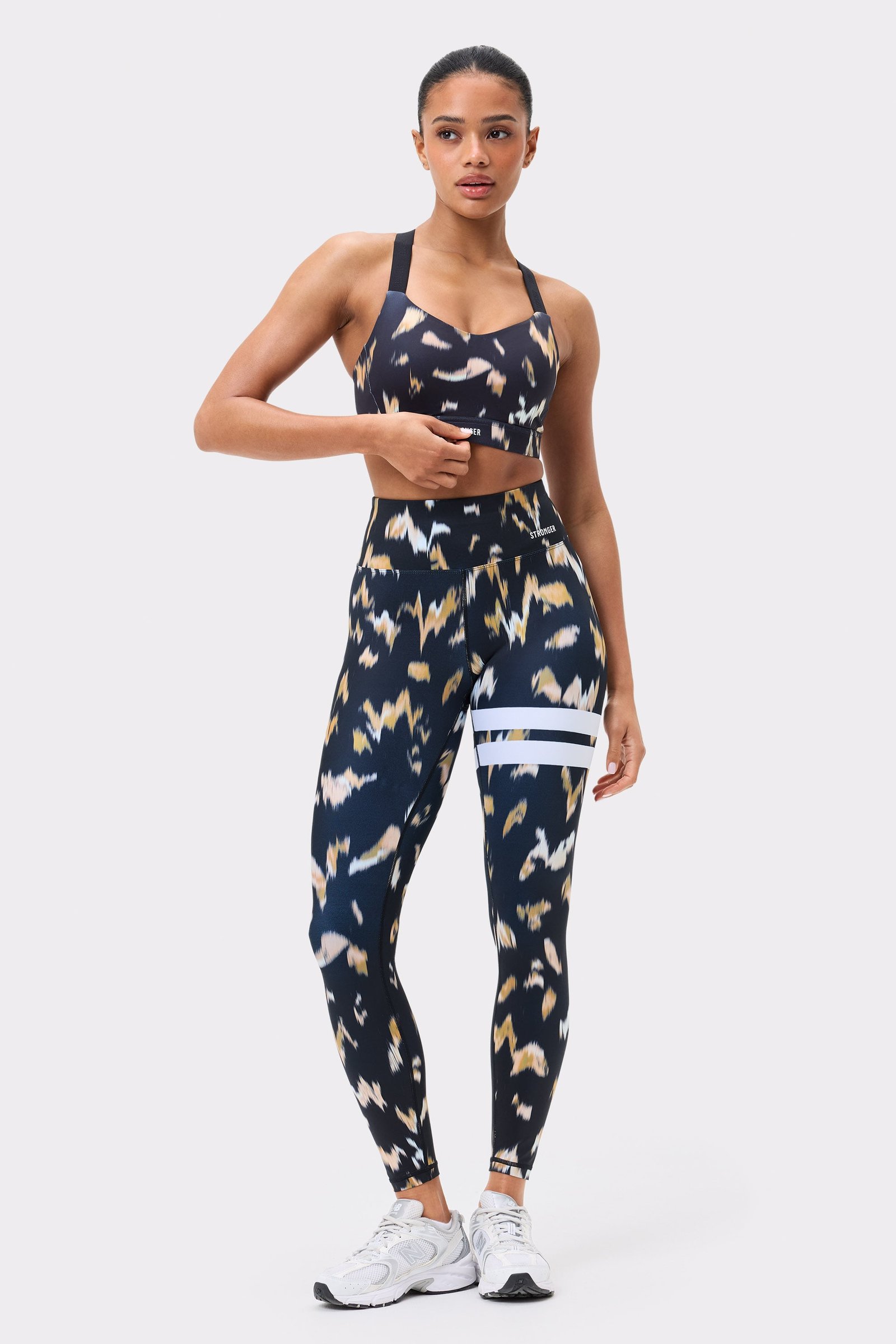 Front view of Stronger's Power Sports Bra and matching leggings in Savannah Print with white stripe details.